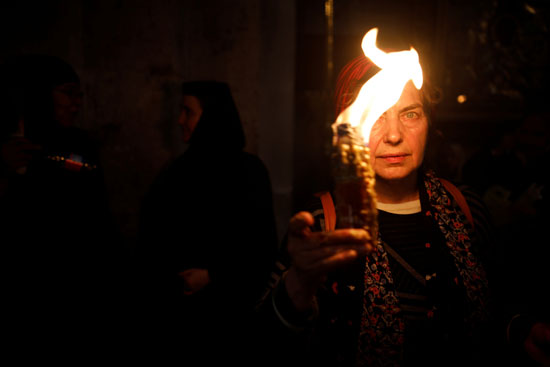  سيدة تحمل شعلة داخل كنيسة القبر المقدس