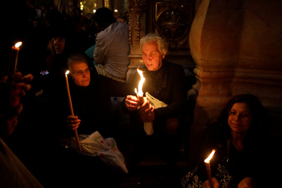  سيدات الأقباط يحملن الشعلات المضيئة داخل كنيسة القبر المقدس
