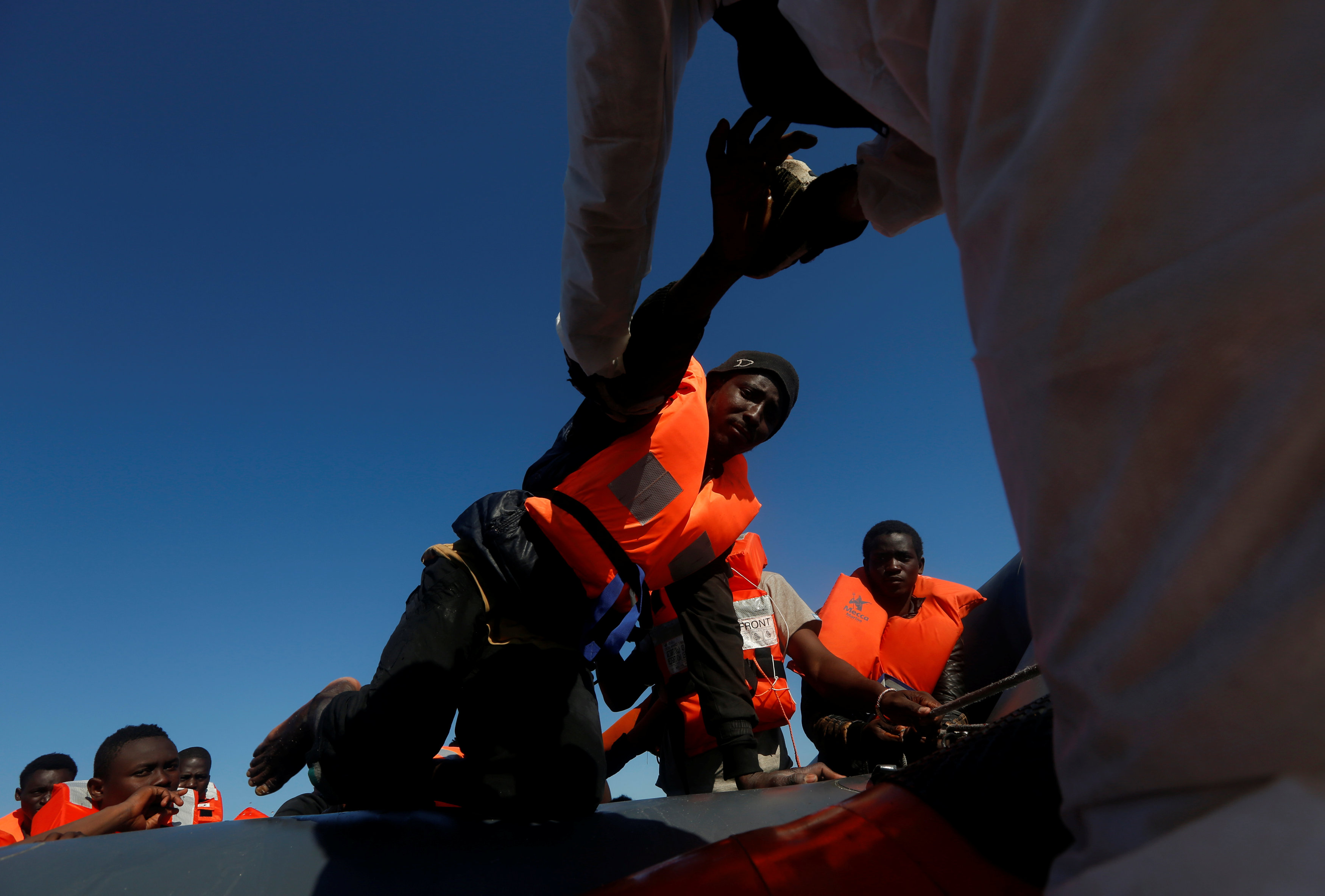 جانب من نقل المهاجرين من الزورق الى سفينة الانقاذ
