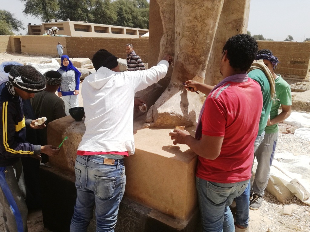 8- المرممون المصريون يستخدمون الفرش لتنظيف تمثال ملكي