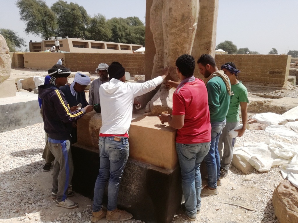 9- ثمانية شباب يقومون بتنظيف أحد التماثيل المستخرجة بمعرفة البعثات الاجنبية