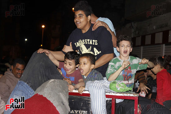 أطفال يلهون حول دمية اللمبى