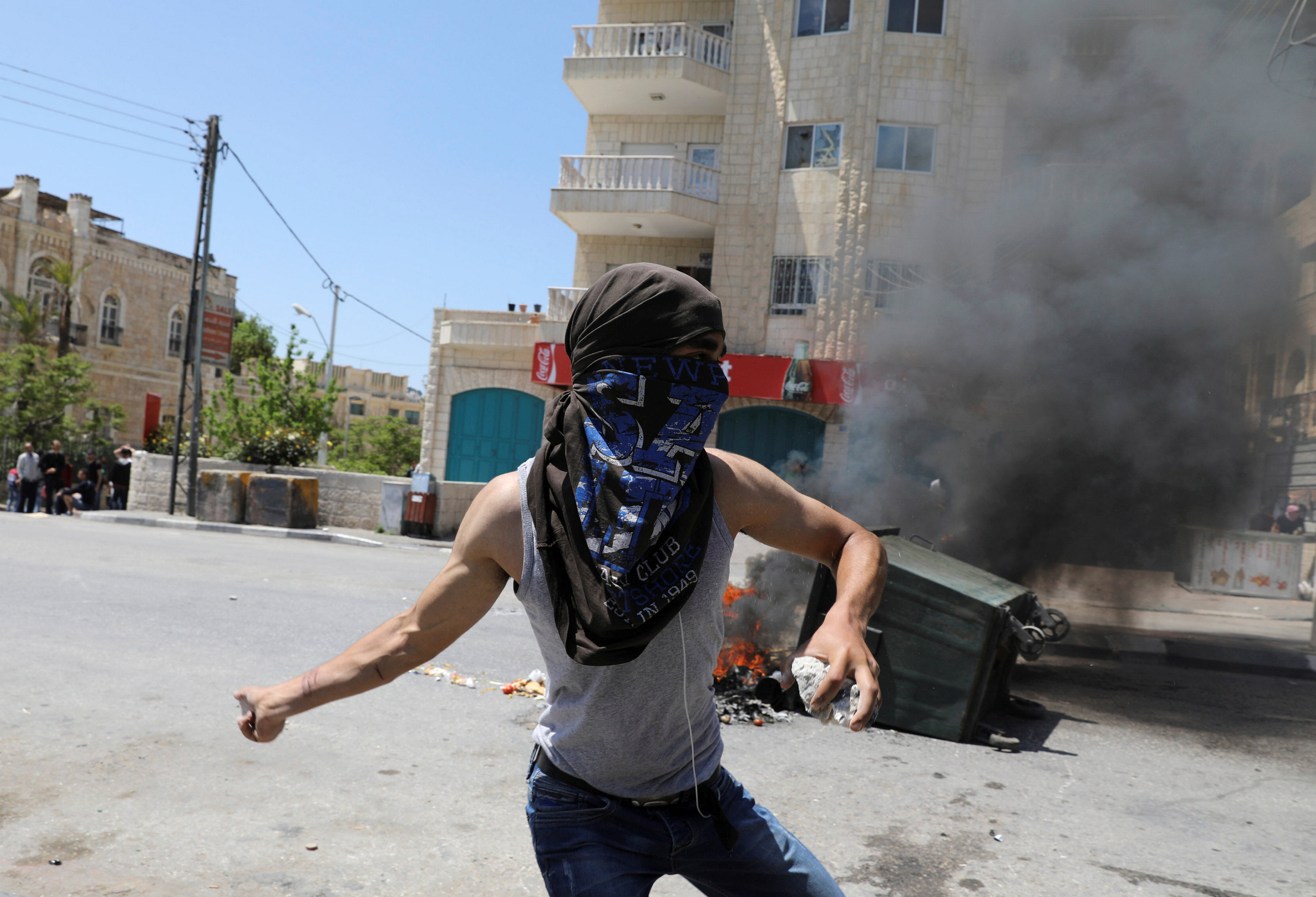 متظاهر يرشق قوات الاحتلال بالحجارة
