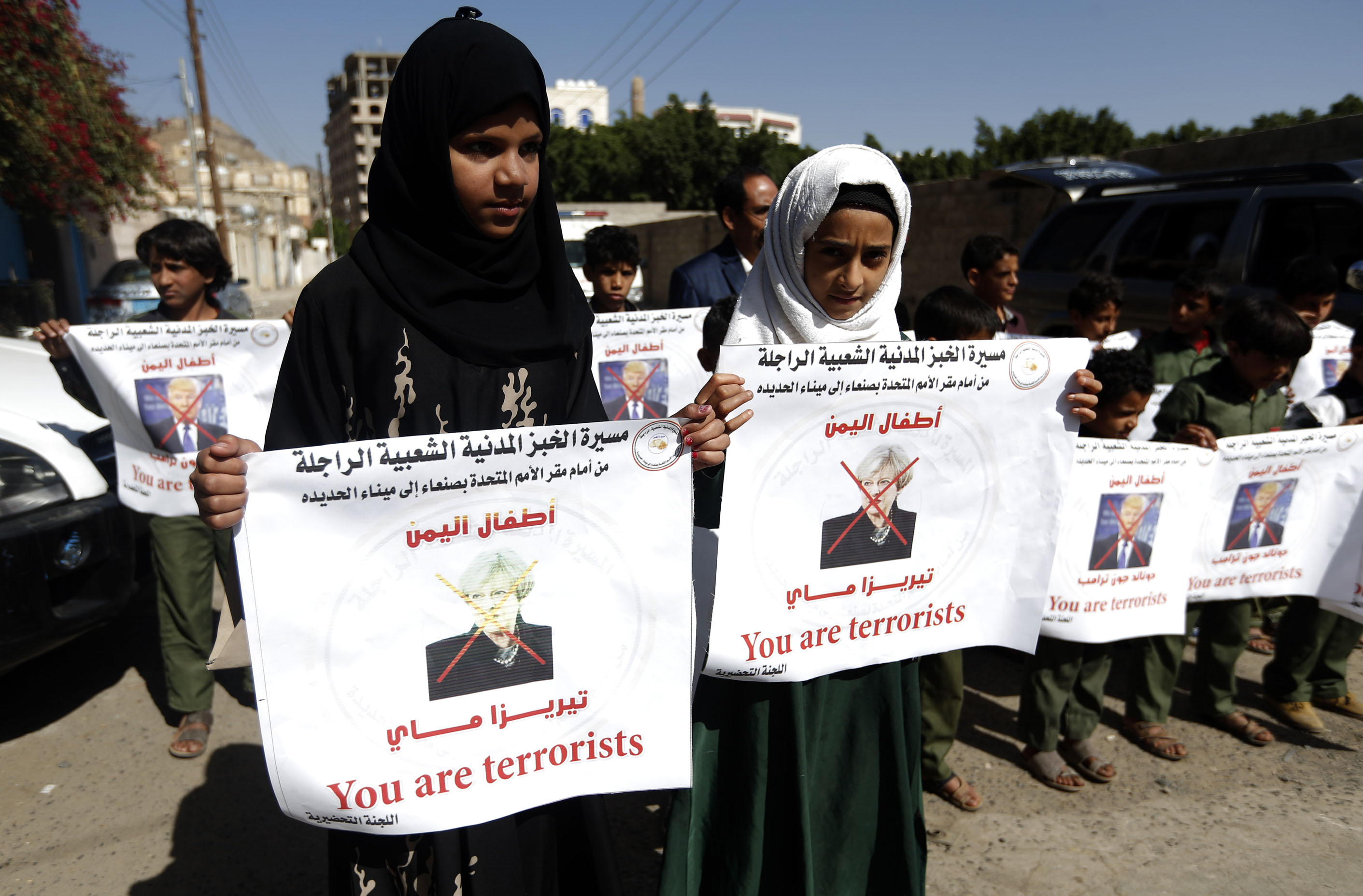 فتيات يحملن لافتات خلال الوقفة الاحتجاجية