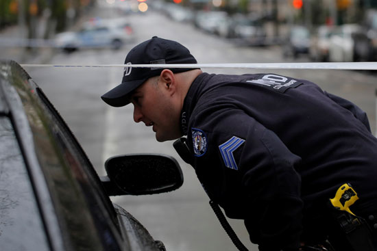 شرطى أمريكى يفتش سيارة مشبوهة بالقرب من القنصلية الفرنسية