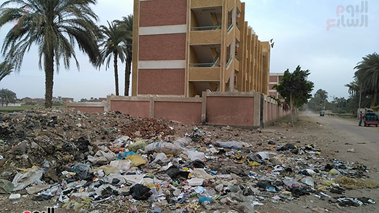  القمامة ومخلفات البناء بجوار سور المدرسة