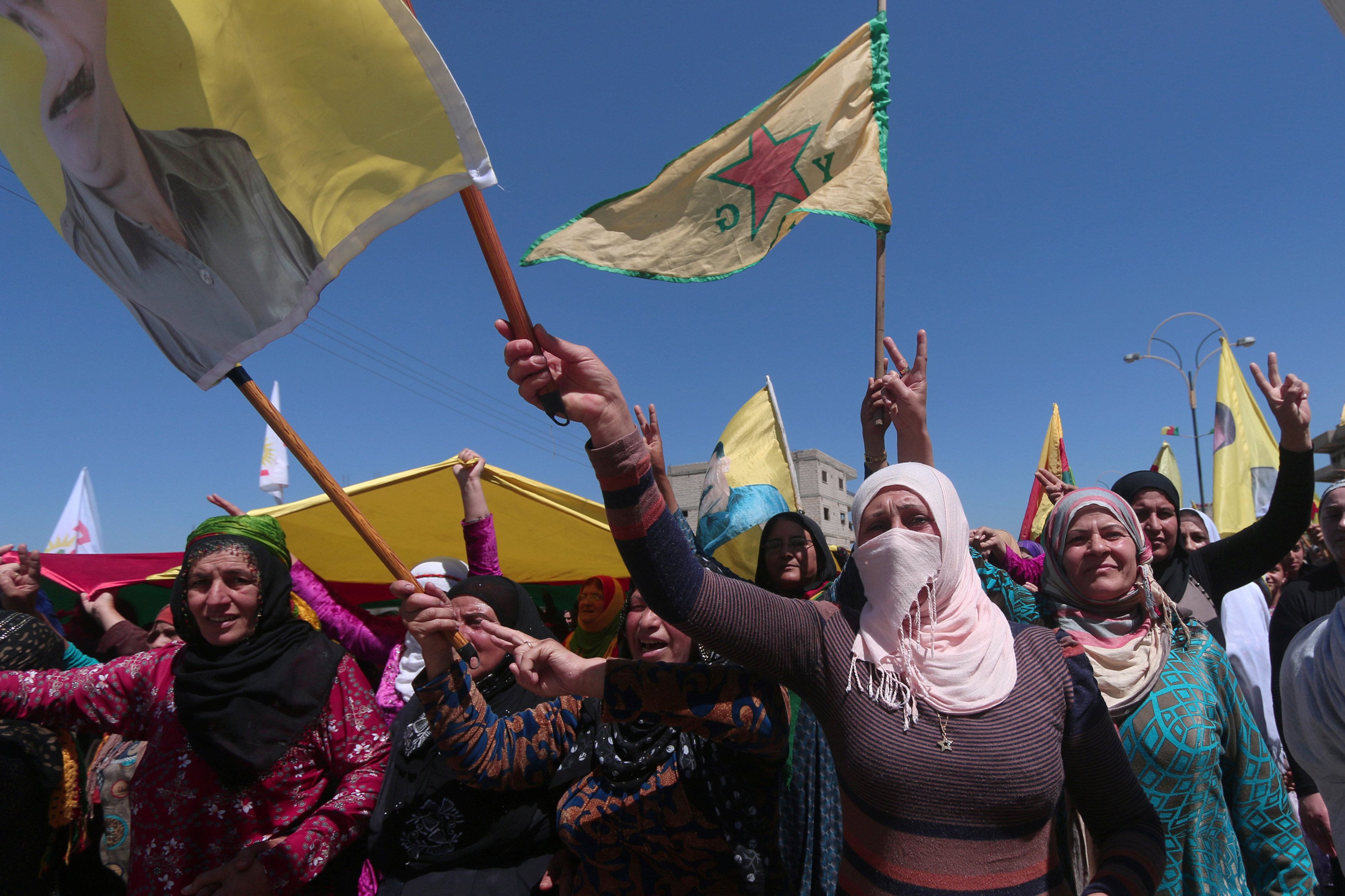 نساء كرديات يحملن الأعلام خلال المظاهرة