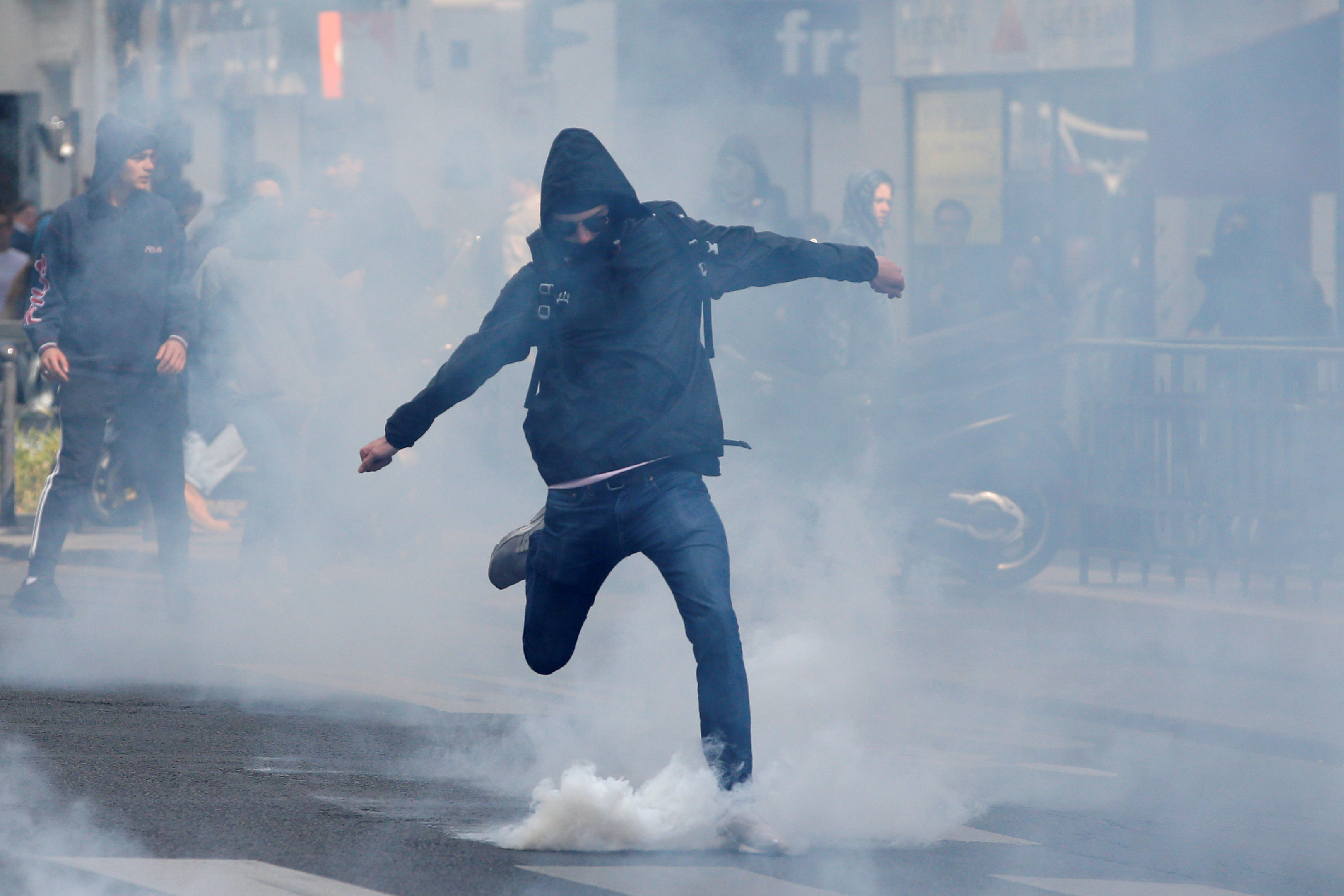 متظاهر فرنسى يركل قنبلة غاز خلال اشتباكات مع الشرطةمظاهرات ضد الجبهة الوطنية اليمنية المتطرفة فى فرنسا