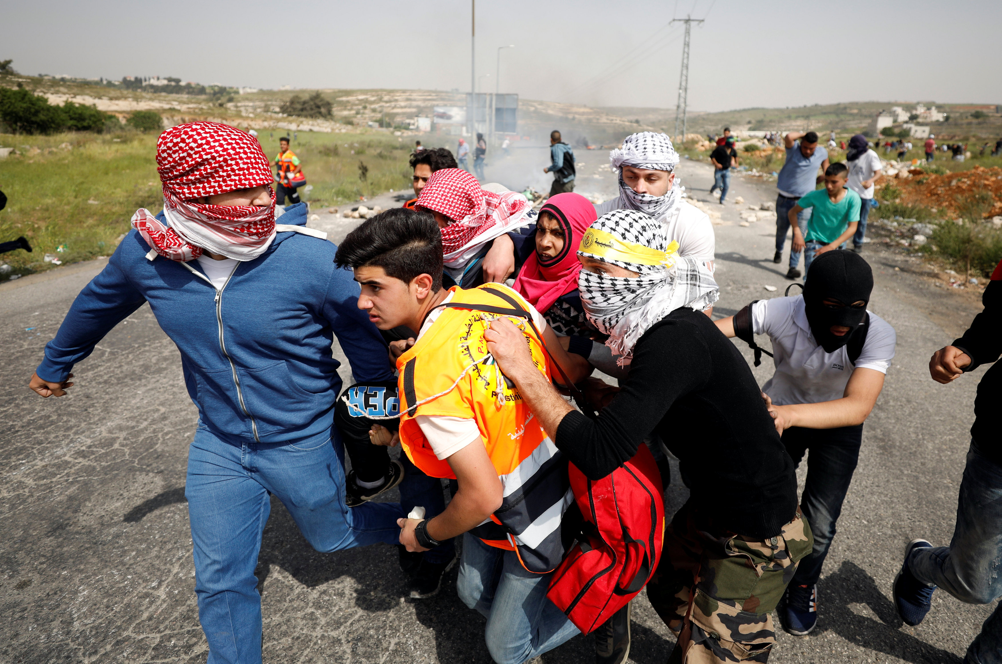 شباب فلسطينيين يحملون مصابا برصاص قوات الاحتلال