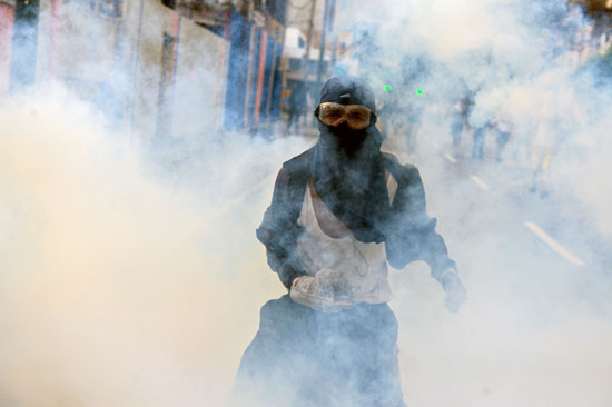 أحد المحتجين وسط الغاز المسيل للدموع