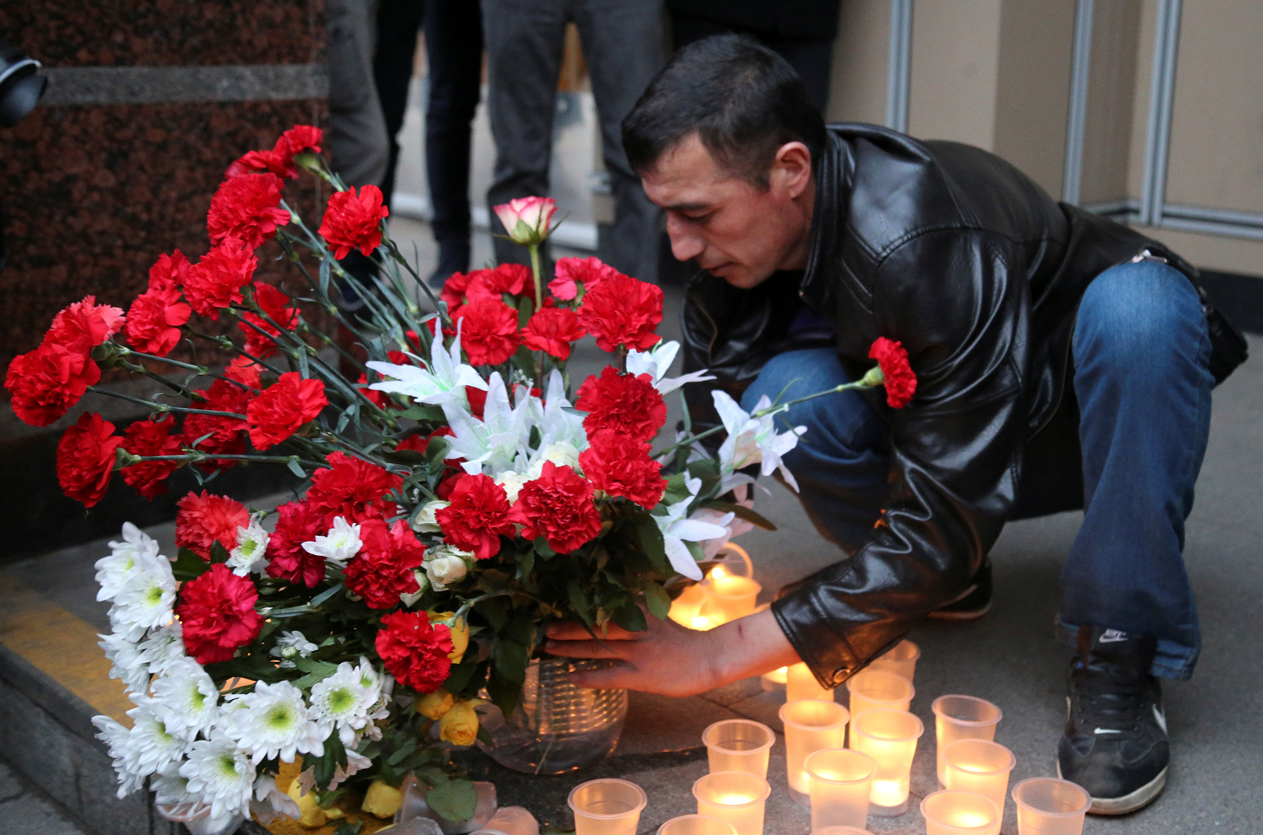 شخص يضع أكليل من الزهور تكريما لضحايا حادث انفجار مترو بطرسبرج
