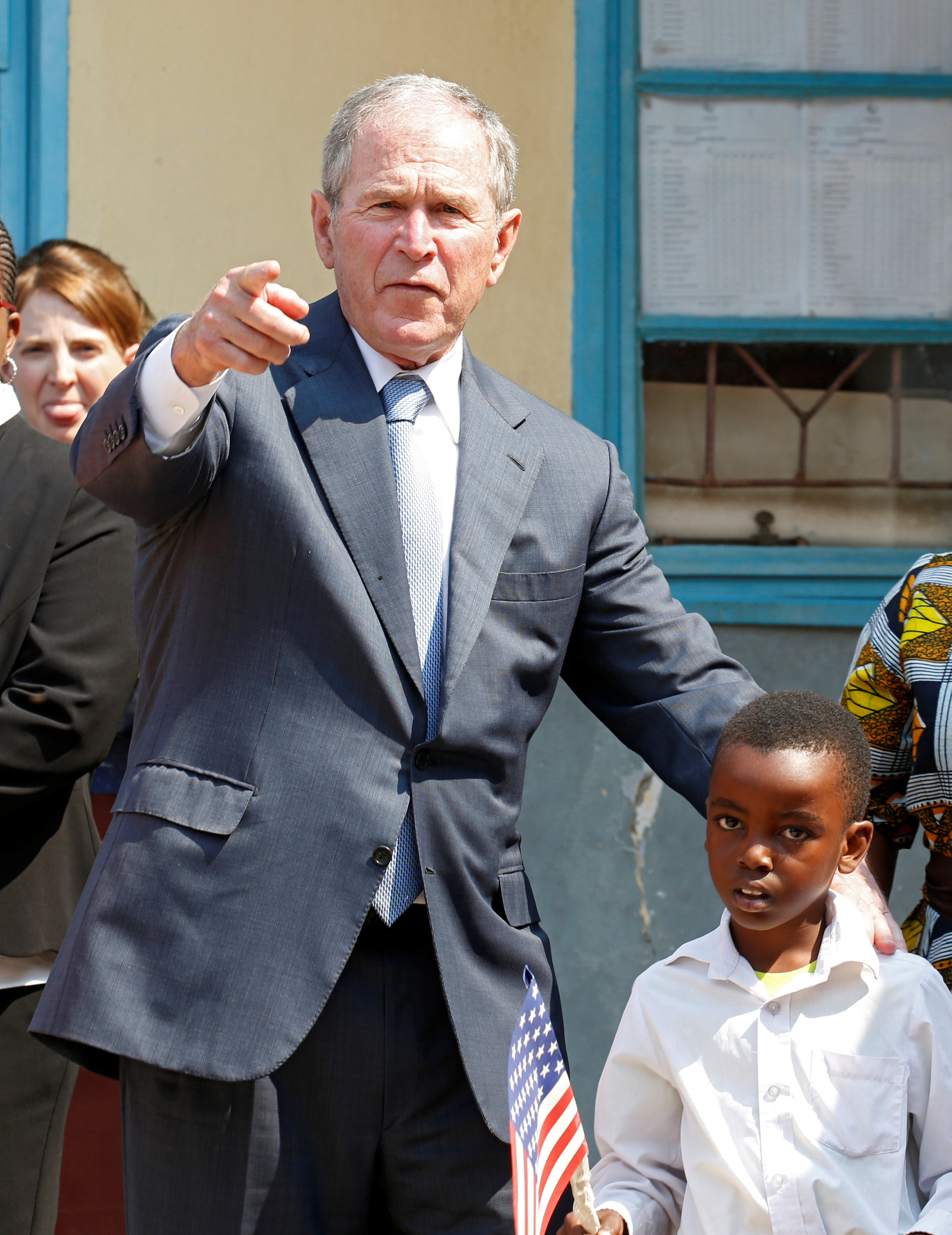 جورج بوش يتلقط صورة مع طفل صغير فى أحدى المدارس