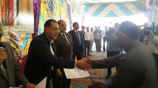 مصطفى مدبولى يسلم أحد المستفيدين عقد الوحدة السكنية