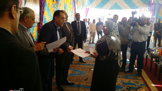 وزير الإسكان يسلم إحدى المستفيدات من المشروع