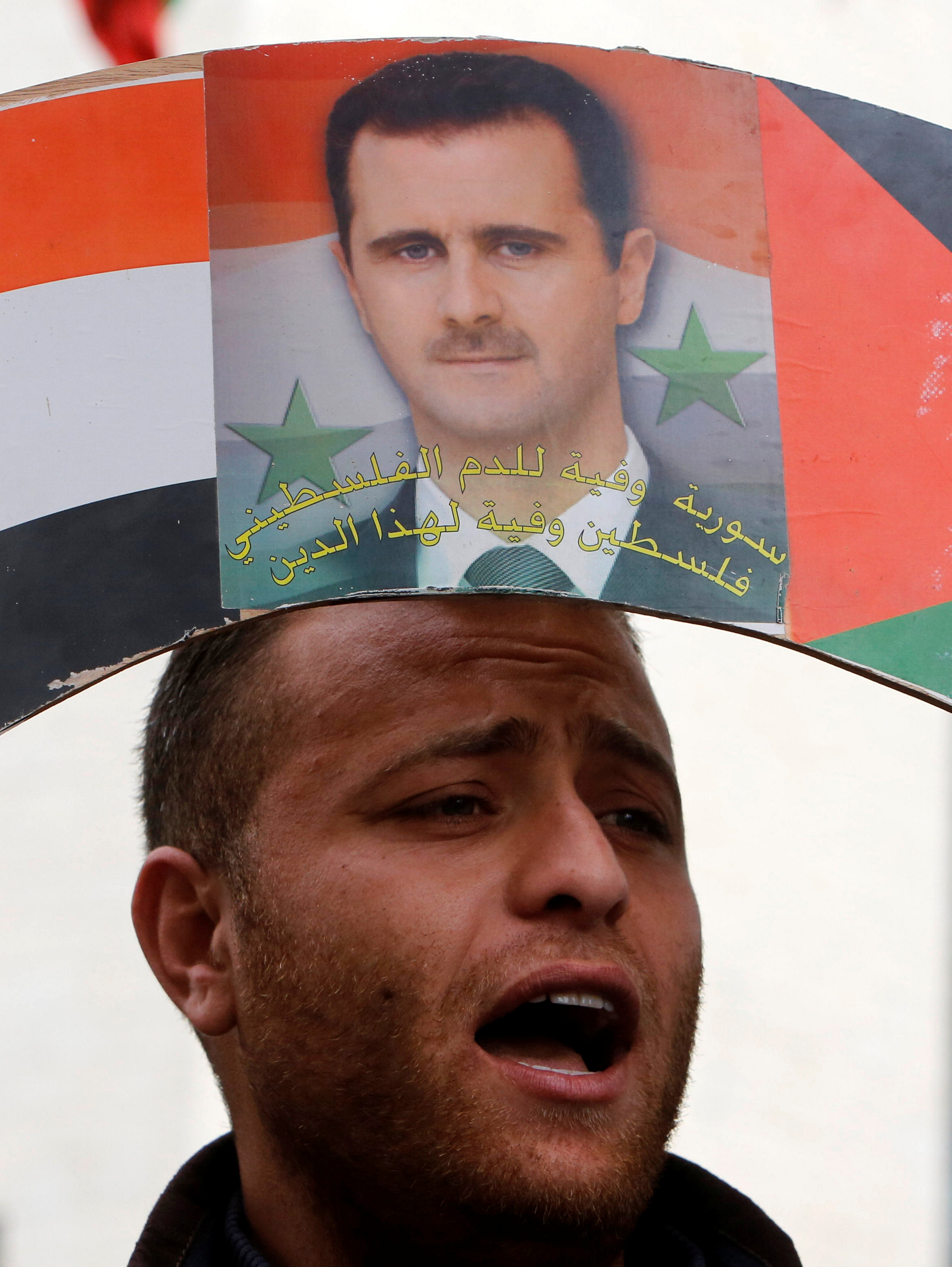 مواطن يحمل صورة الرئيس بشار الأسد
