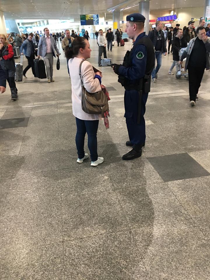 أحد أفراد الأمن يتحدث مع مسافرة