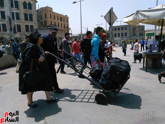 أحد الشيالين خلال حمل حقائب المسافرين