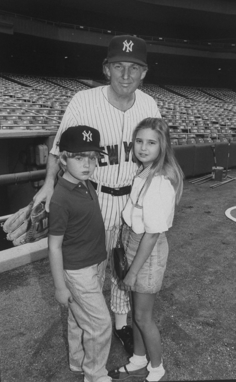 إيفانكا مع والدها مرتديا زى فريق اليانكيز لكرة البايسبول وشقيقها إريك عام 1992