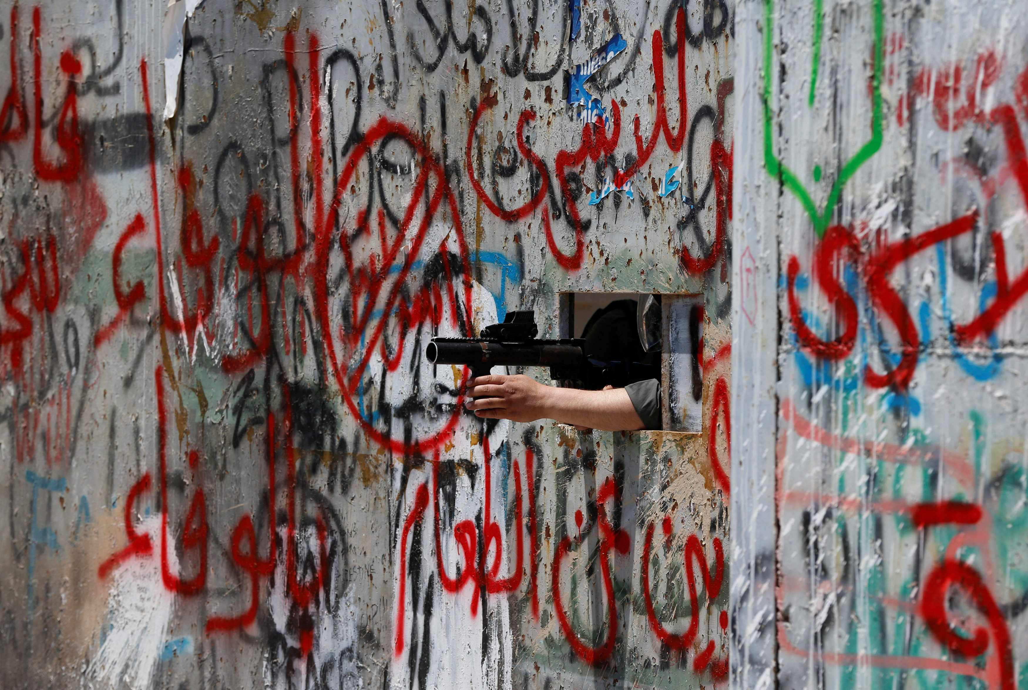 جندى إسرائيلى يوجه سلاحة ضد الفلسطينيين