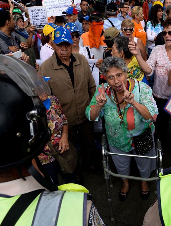 سيدة مسنه تقف وسط المحتجين