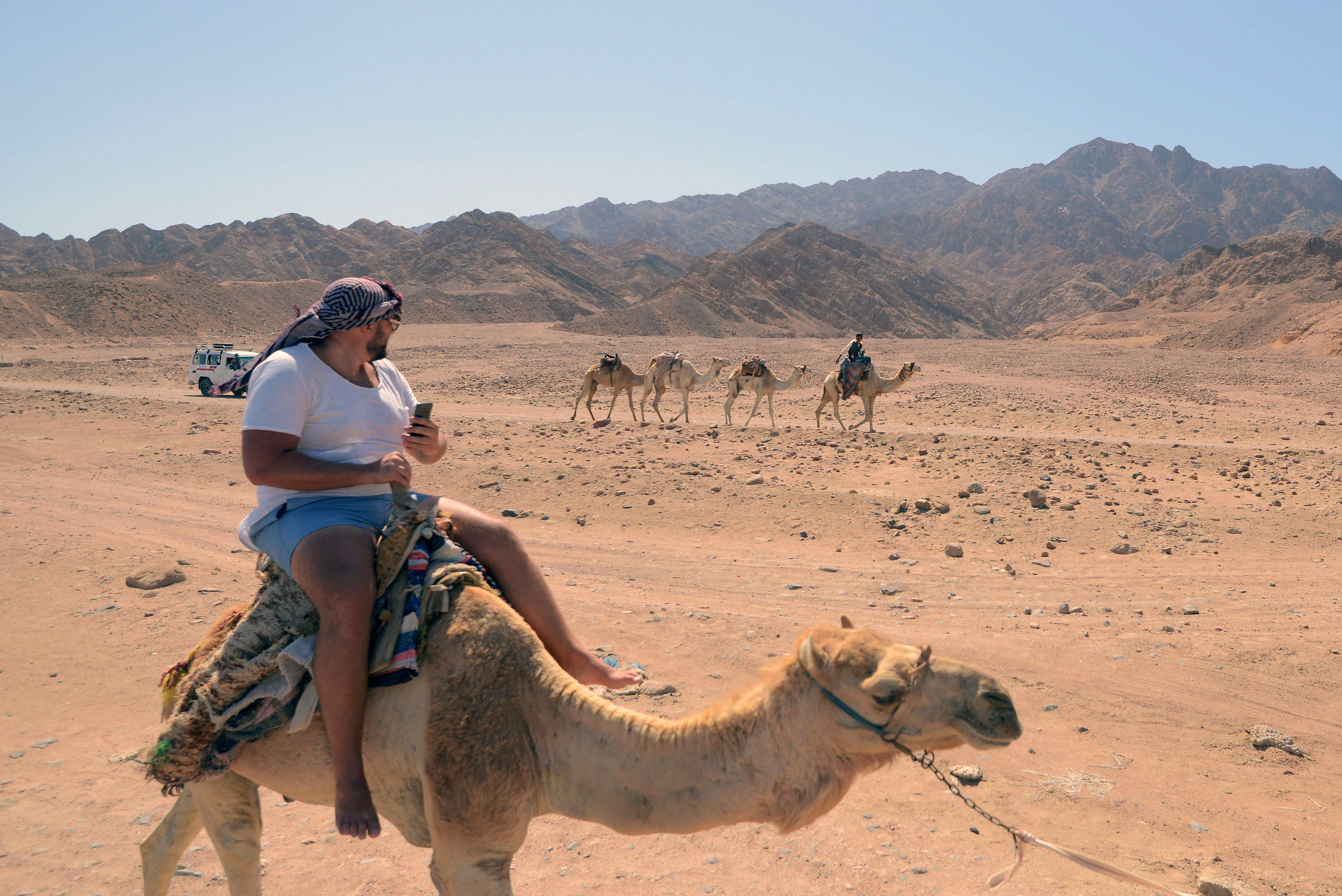 سياح يركبون الجمال وسط الصحراء بجنوب سيناء