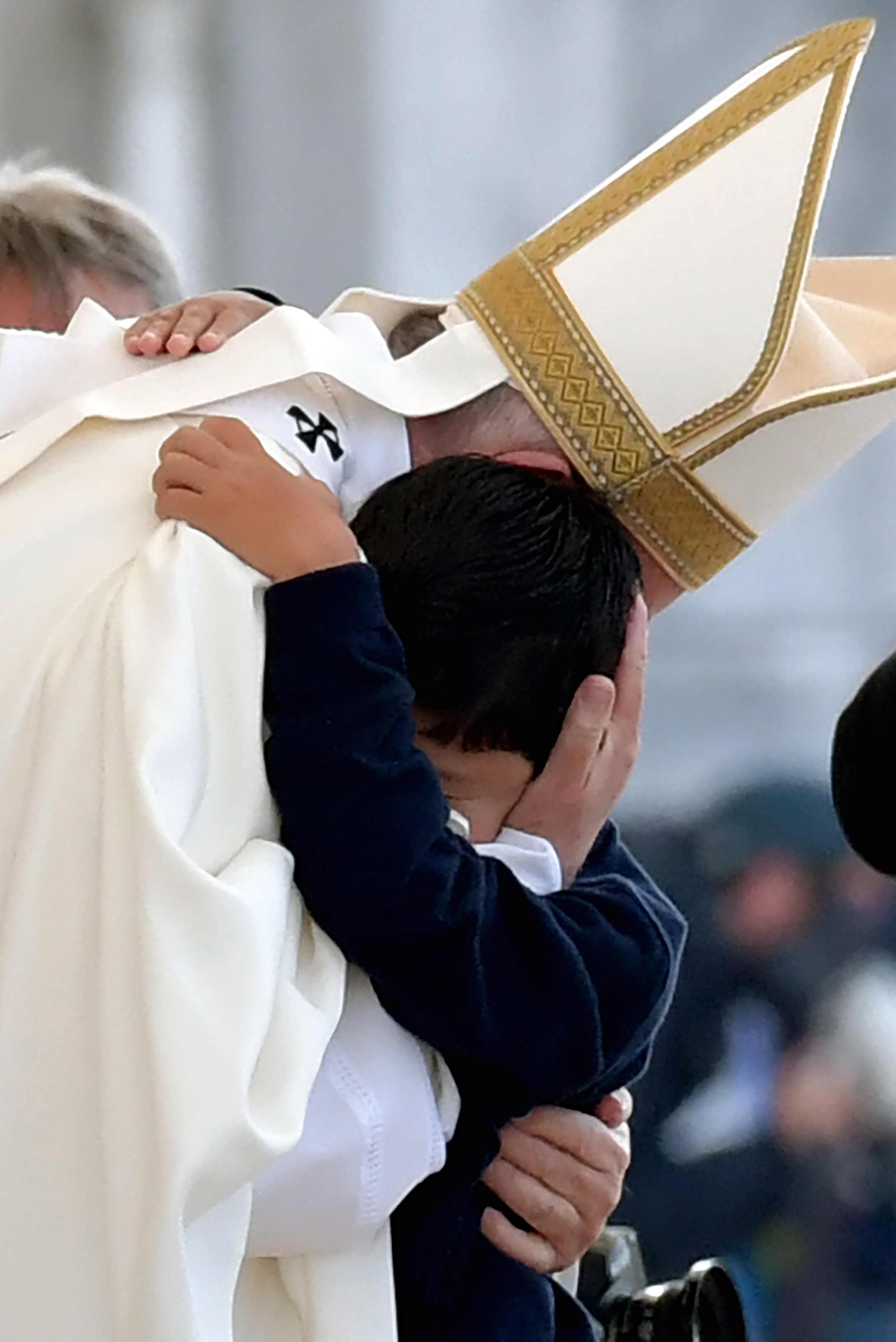 بابا الفاتيكان يضم رأس طفل إلى صدره قبل بداية القداس