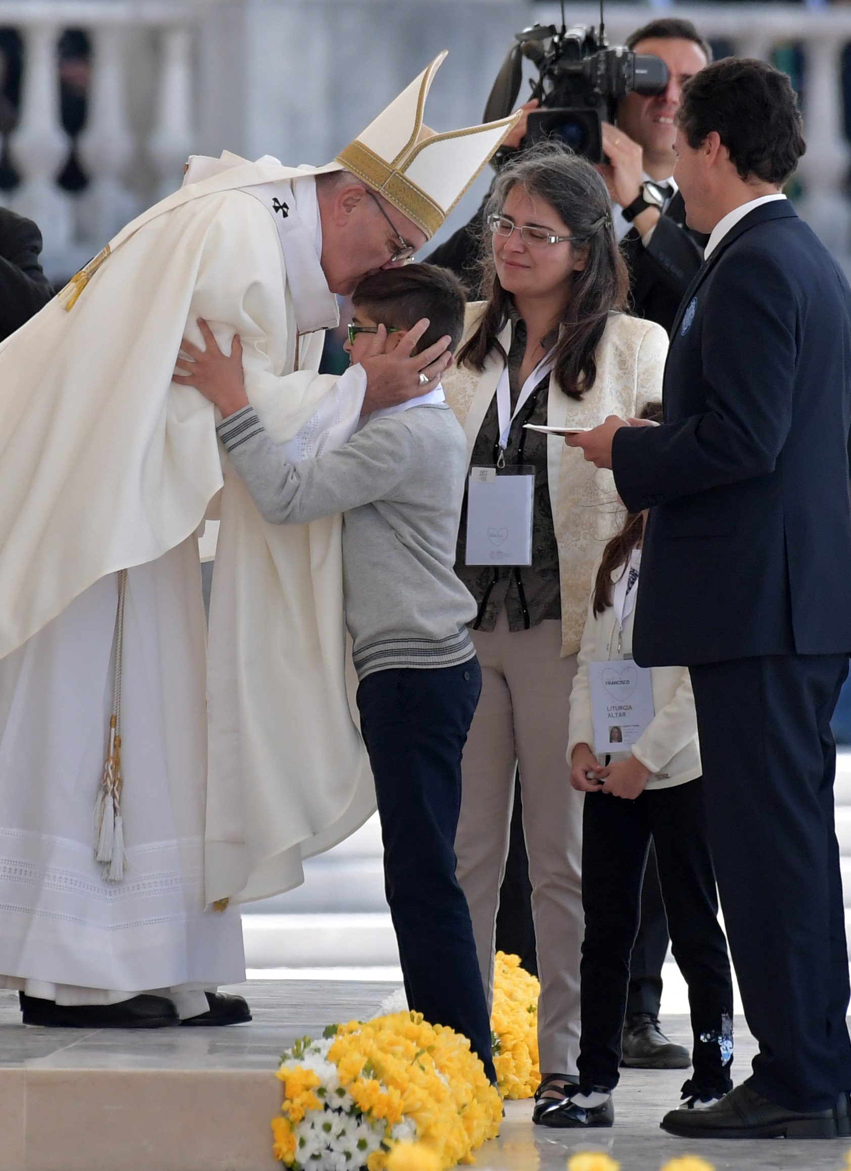 بابا الفاتيكان يقبل رأس طفل قبل قداس ظهور العذراء