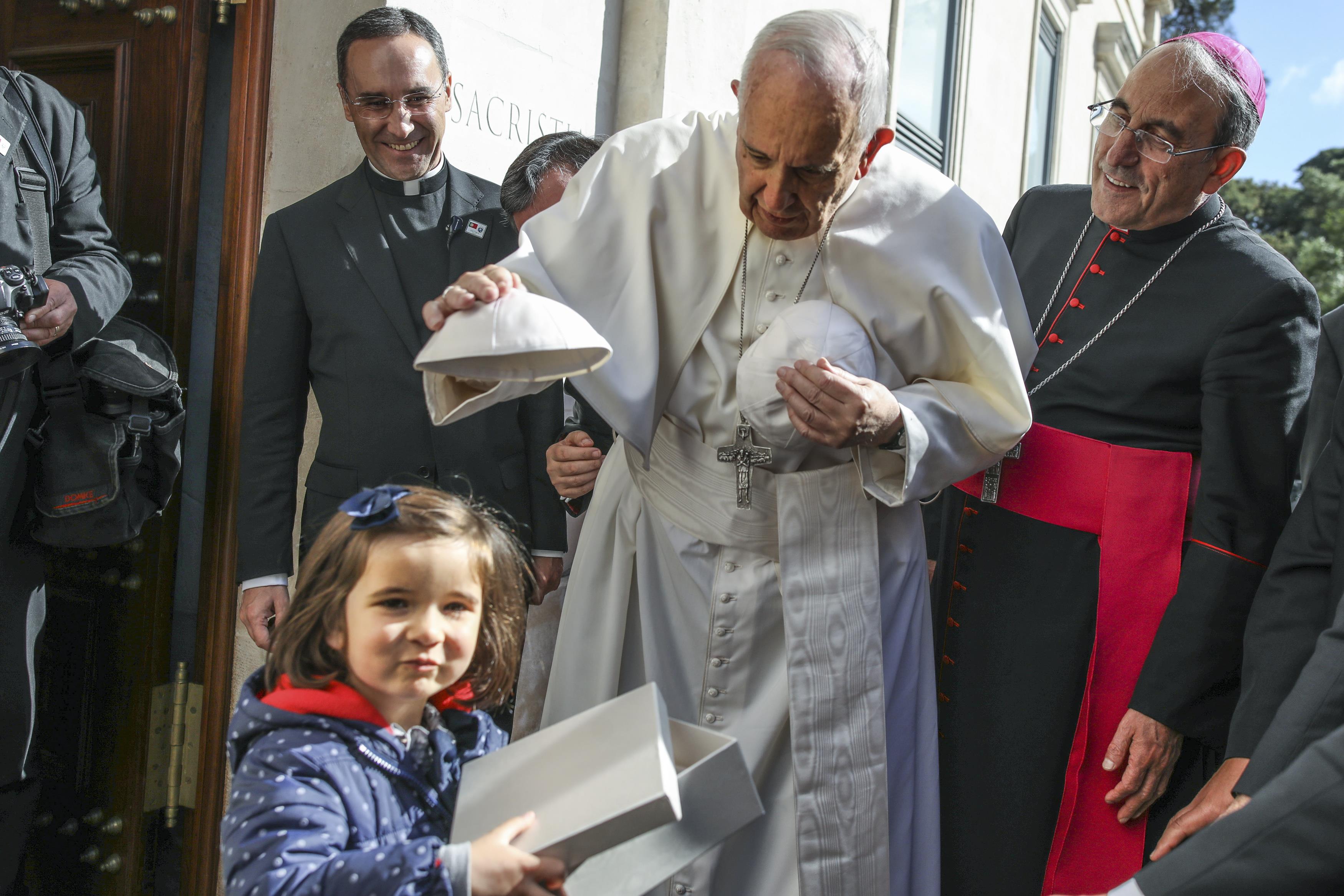 بابا الفاتيكان يضع قبعته على رأس طفلة قبل القداس