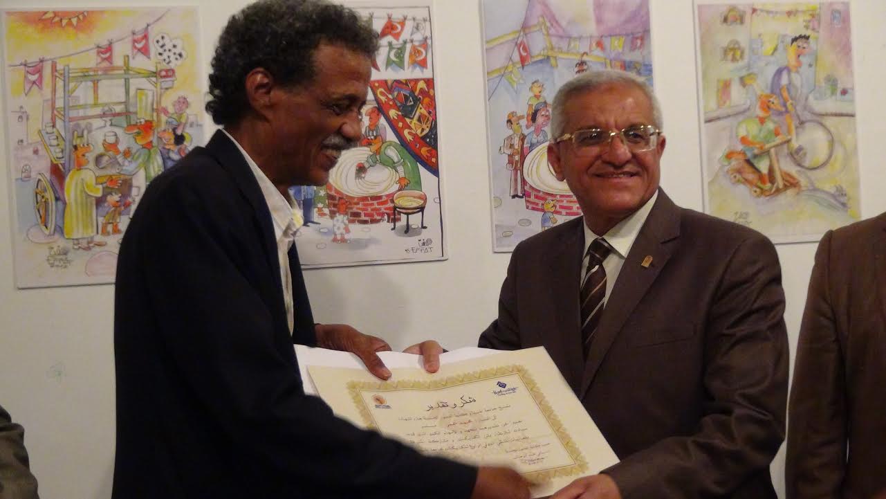 رئيس جامعة المنيا يكرم احد المشاركين فى معرض الكاريكاتير
