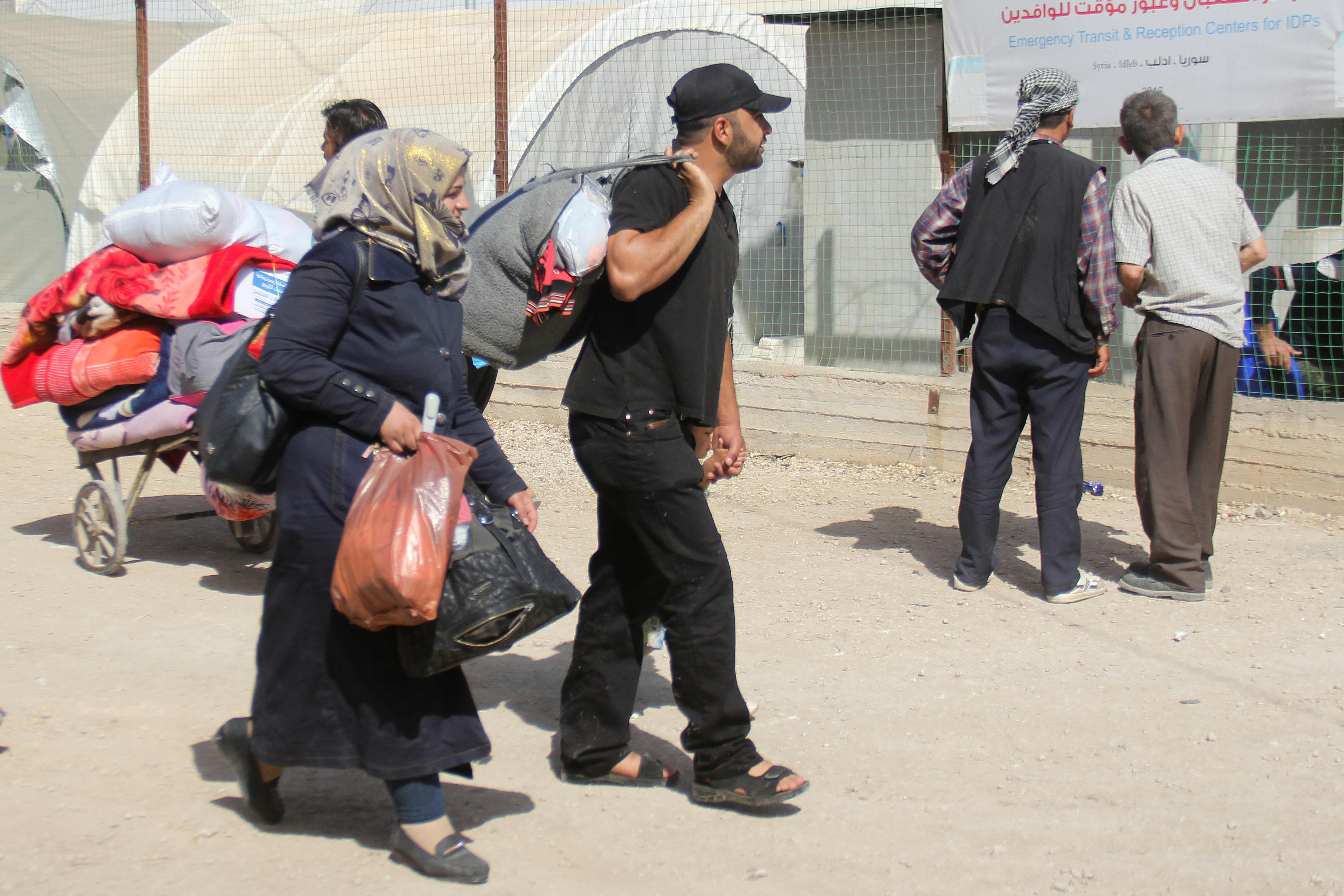 أسر مقاتلو المعارضة المسلحة يحملون أمتعتهم بعد خروجهم من القابون