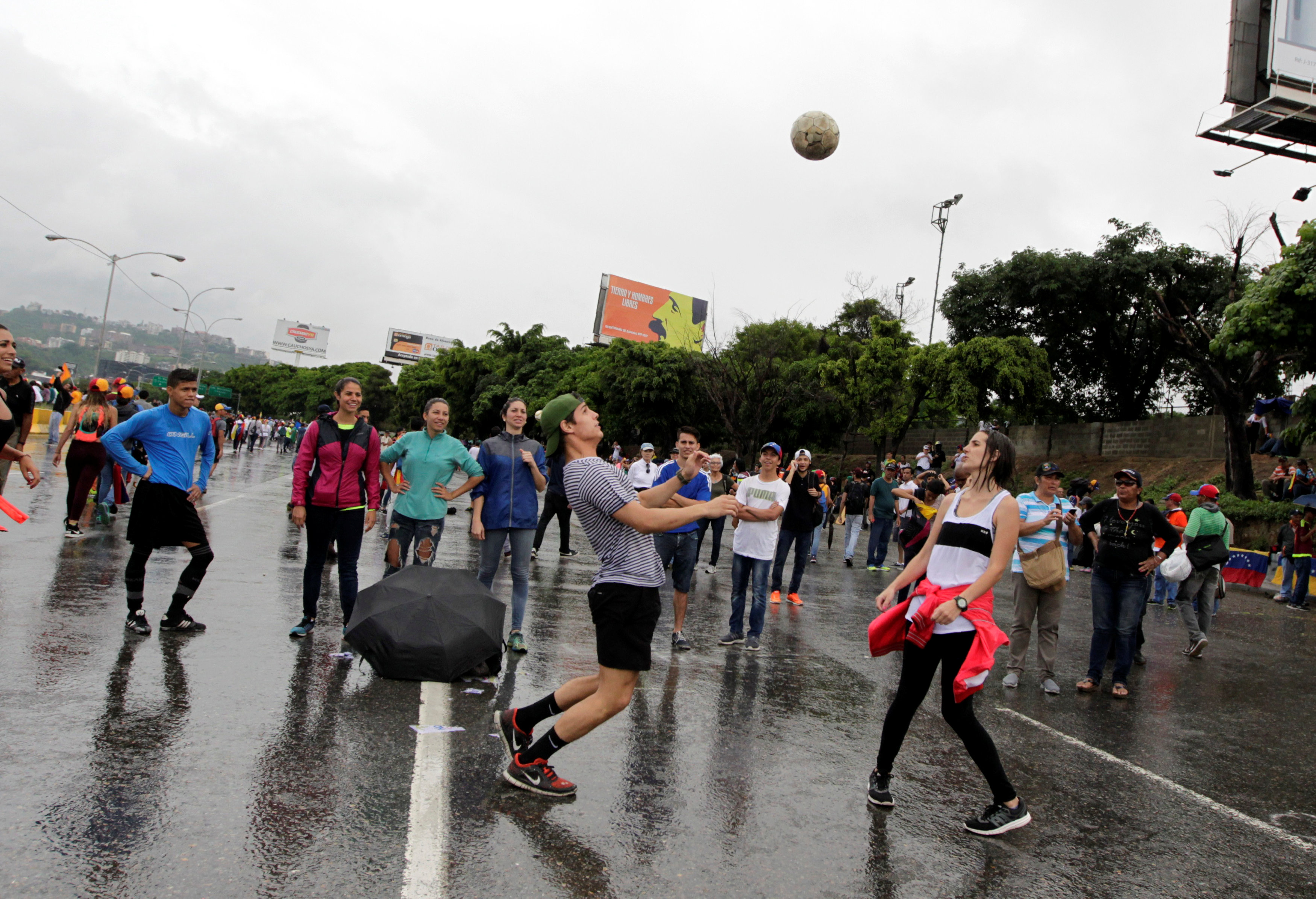 أحد المتظاهرين الفنزويليين يلعب الكرة