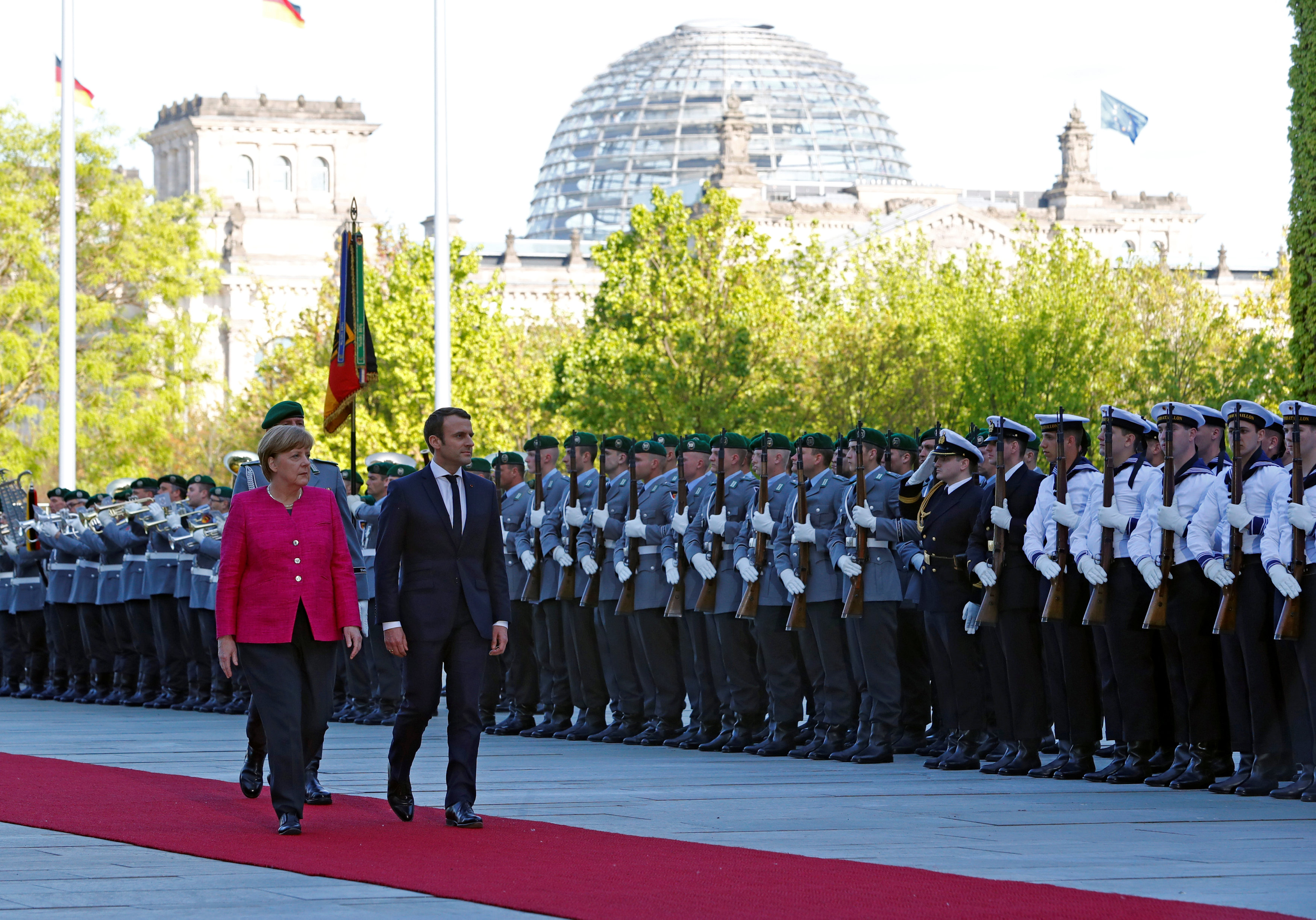 المستشارة الألمانية أنجيلا ميركل والرئيس الفرنسي إيمانويل ماكرون خلال استعراض حرس الشرف في برلين