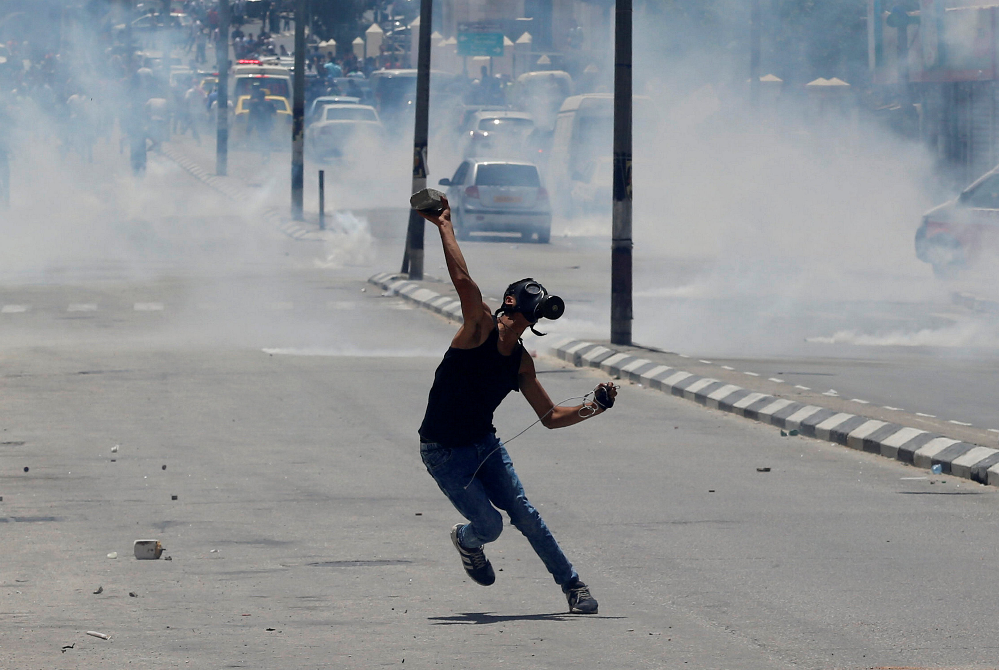 شاب يرتدى ماسك لحمايته من الغاز خلال الاشتباكات