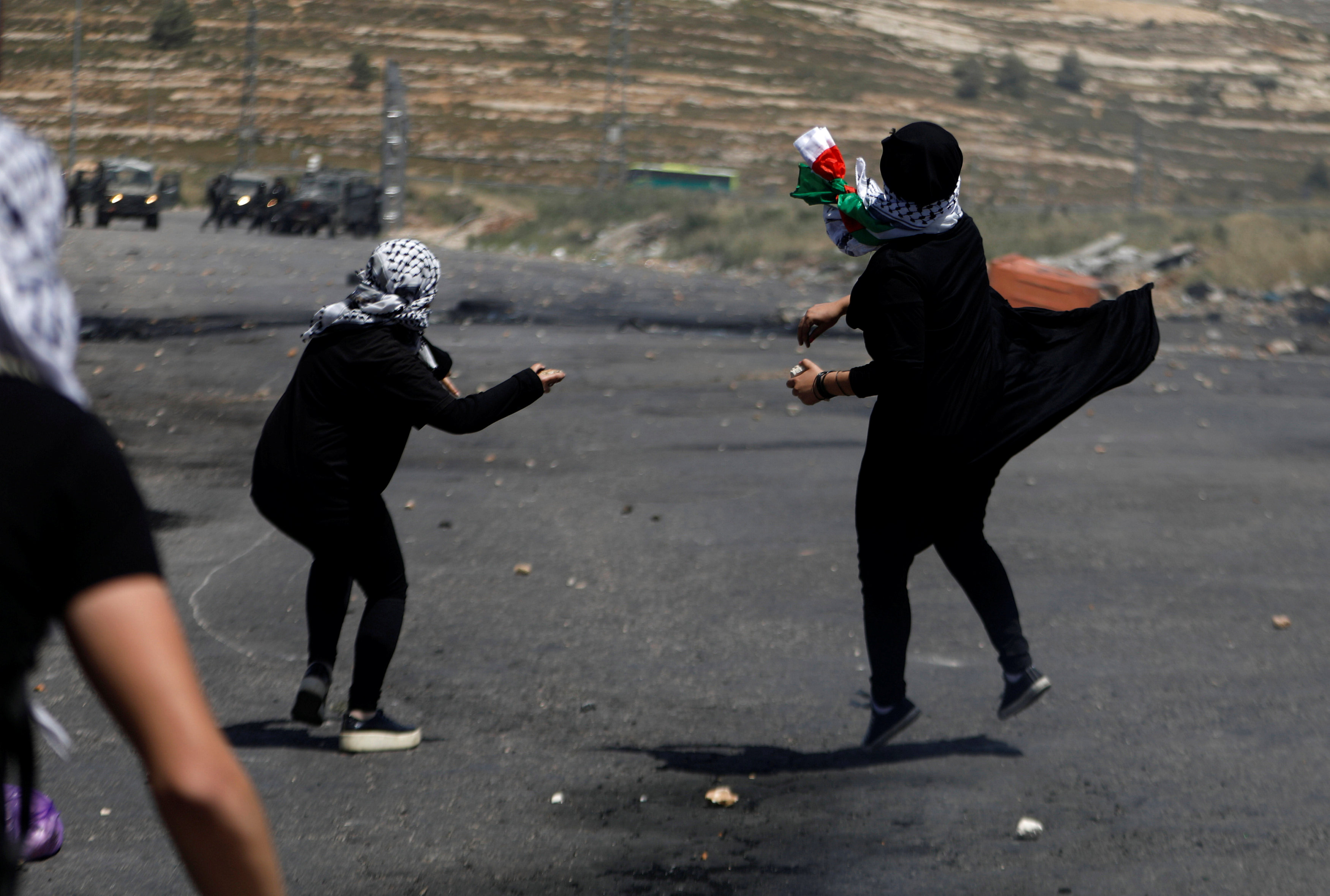 فتيات يلقين الحجارة باتجاه قوات الاحتلال الاسرائيلى