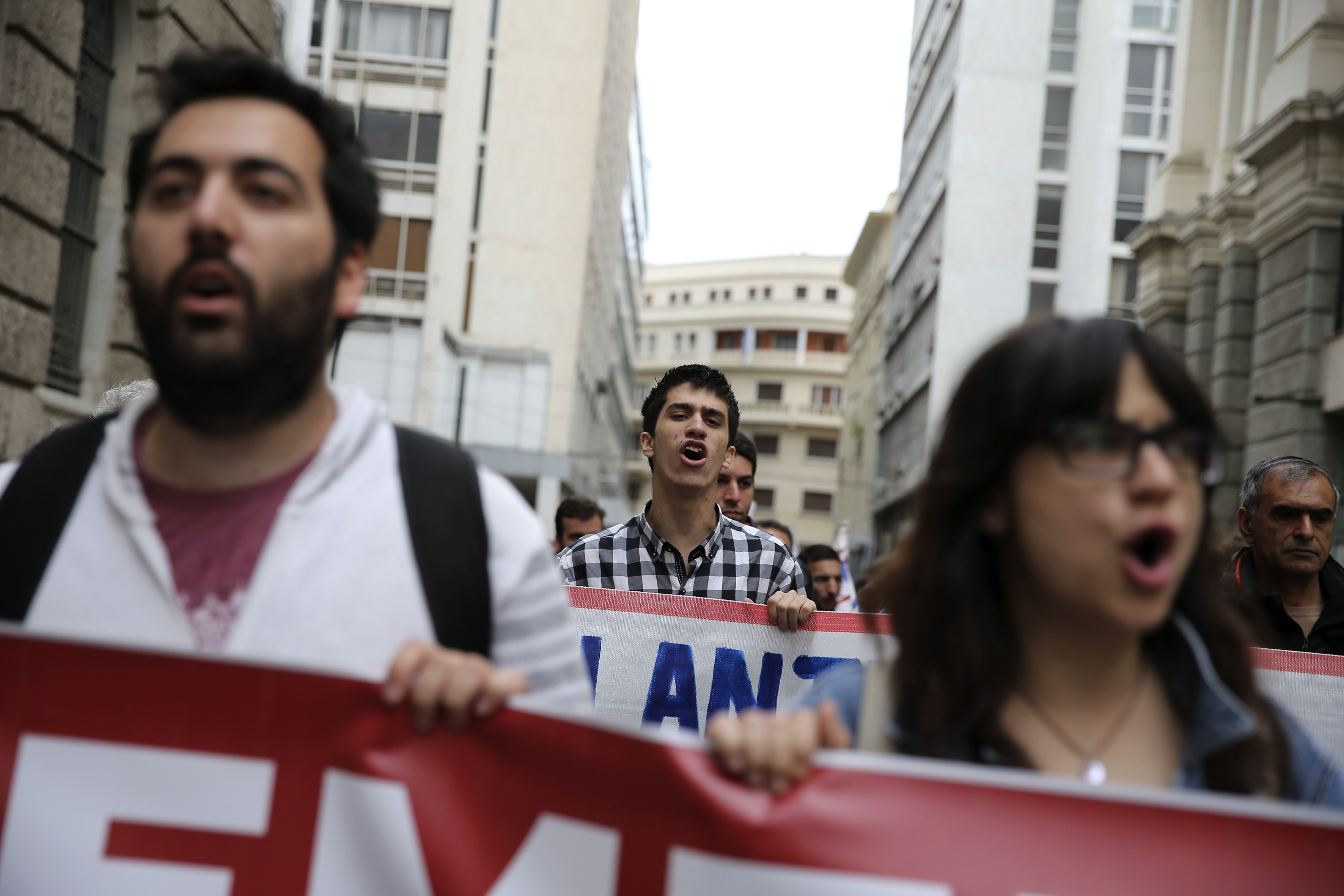 احدى المتظاهرين يحملون أعلام اليونان