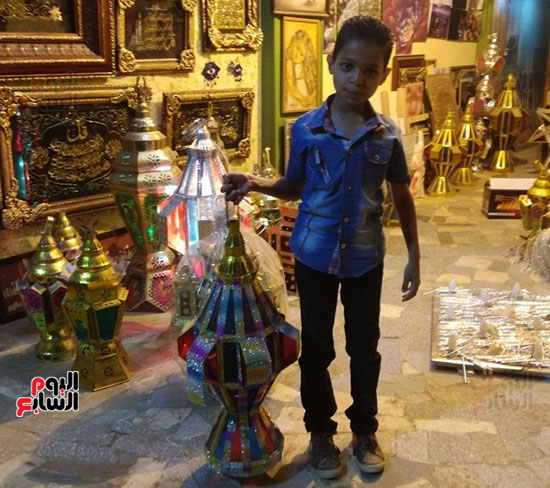طفل يشتري فانوس رمضان من ورشة الحاج حمودة بالأقصر
