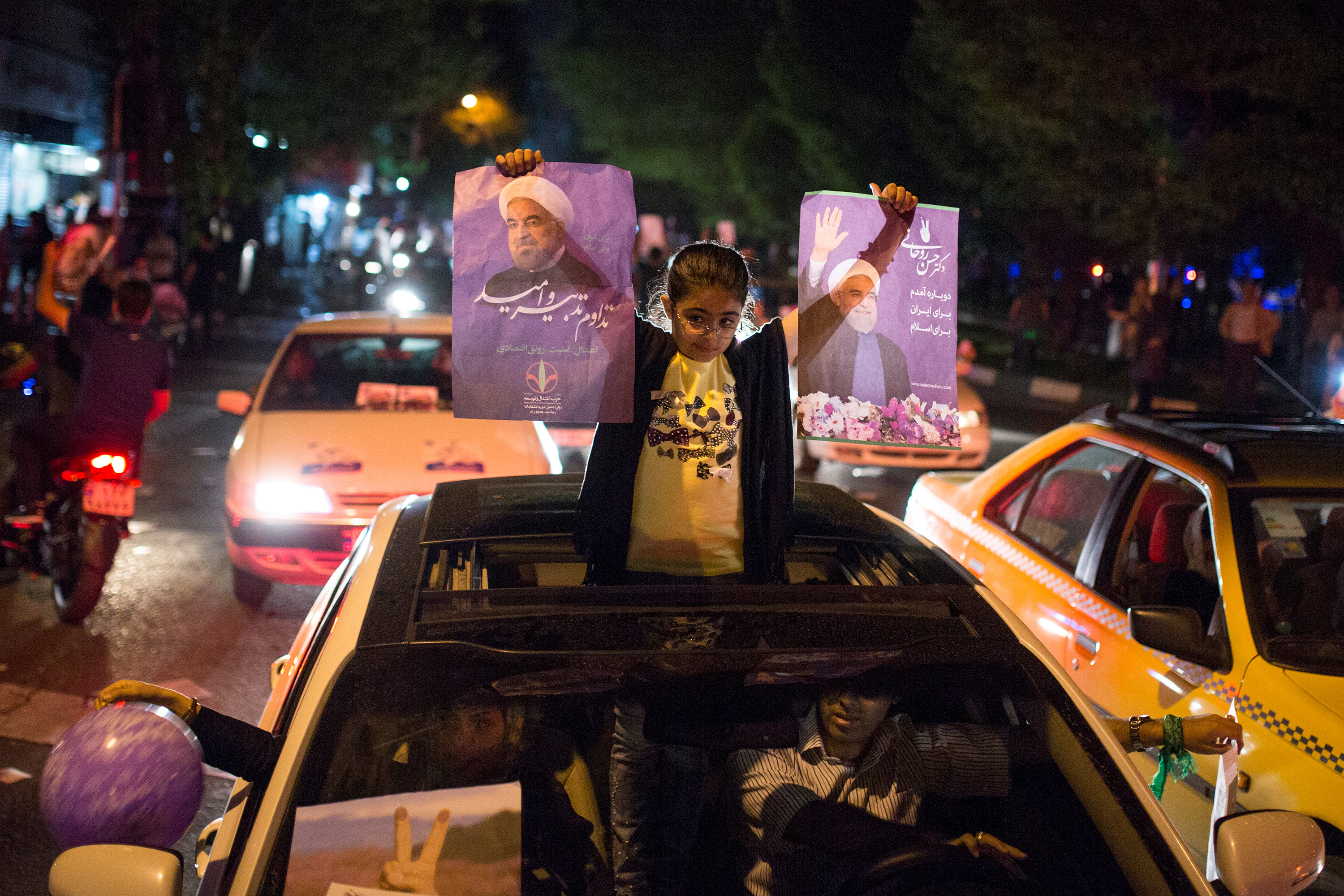 طفلة تحمل صور المرشح لانتخابات الرئاسة الإيرانية حسن روحانى