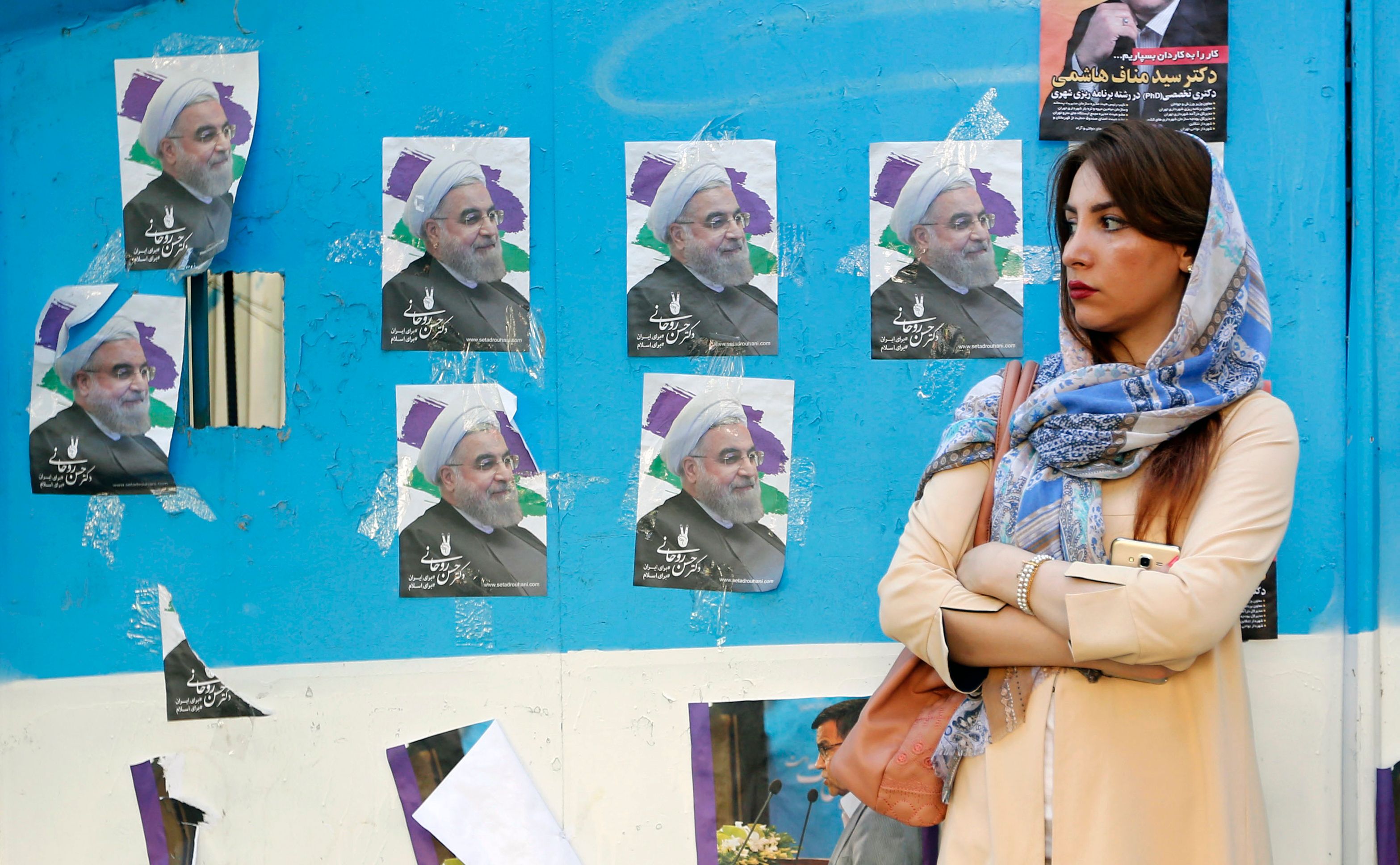 شابة إيرانية بجوار دعاية لروحانى