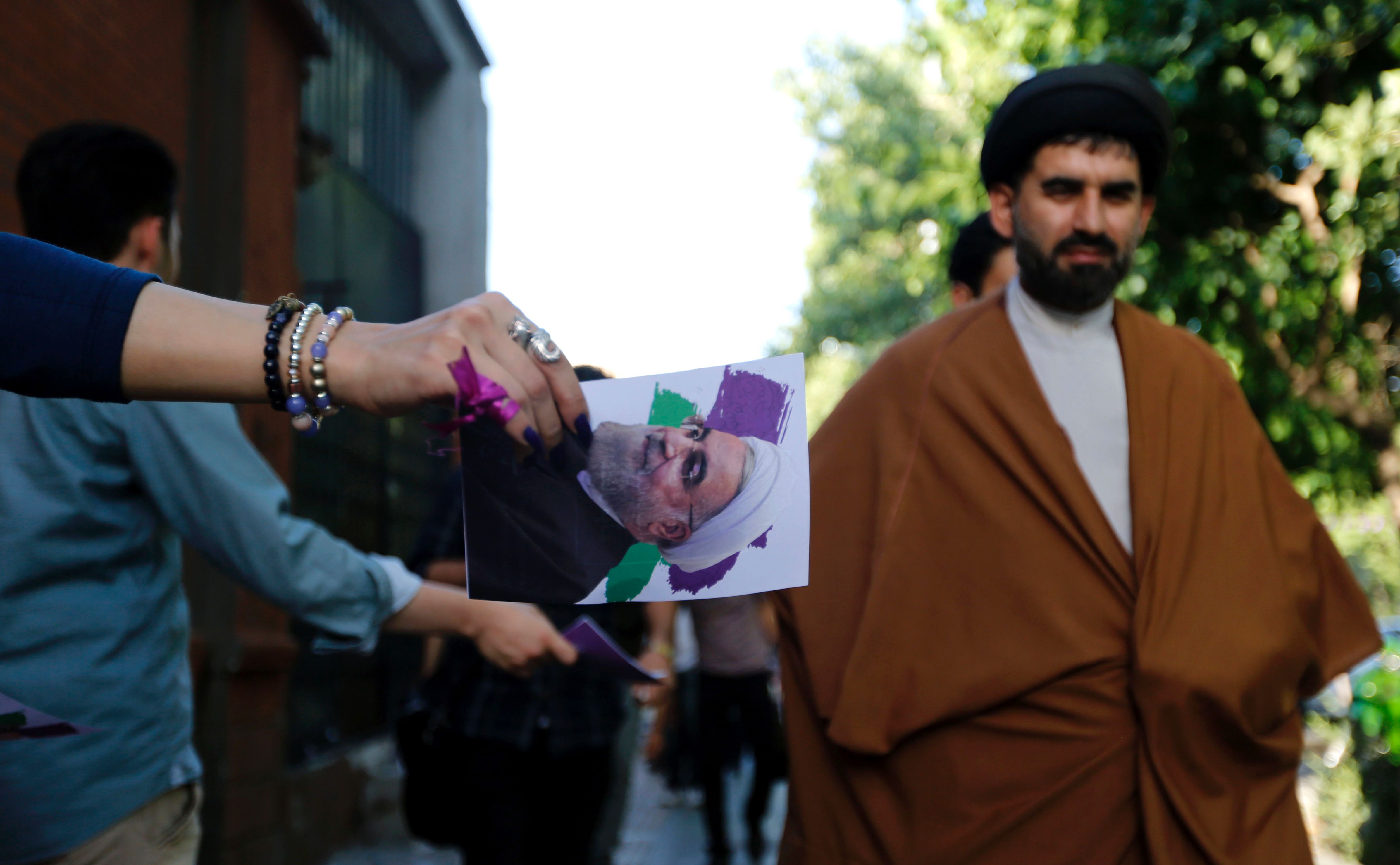 إيرانية توزع دعاية لروحانى فى شوارع طهران