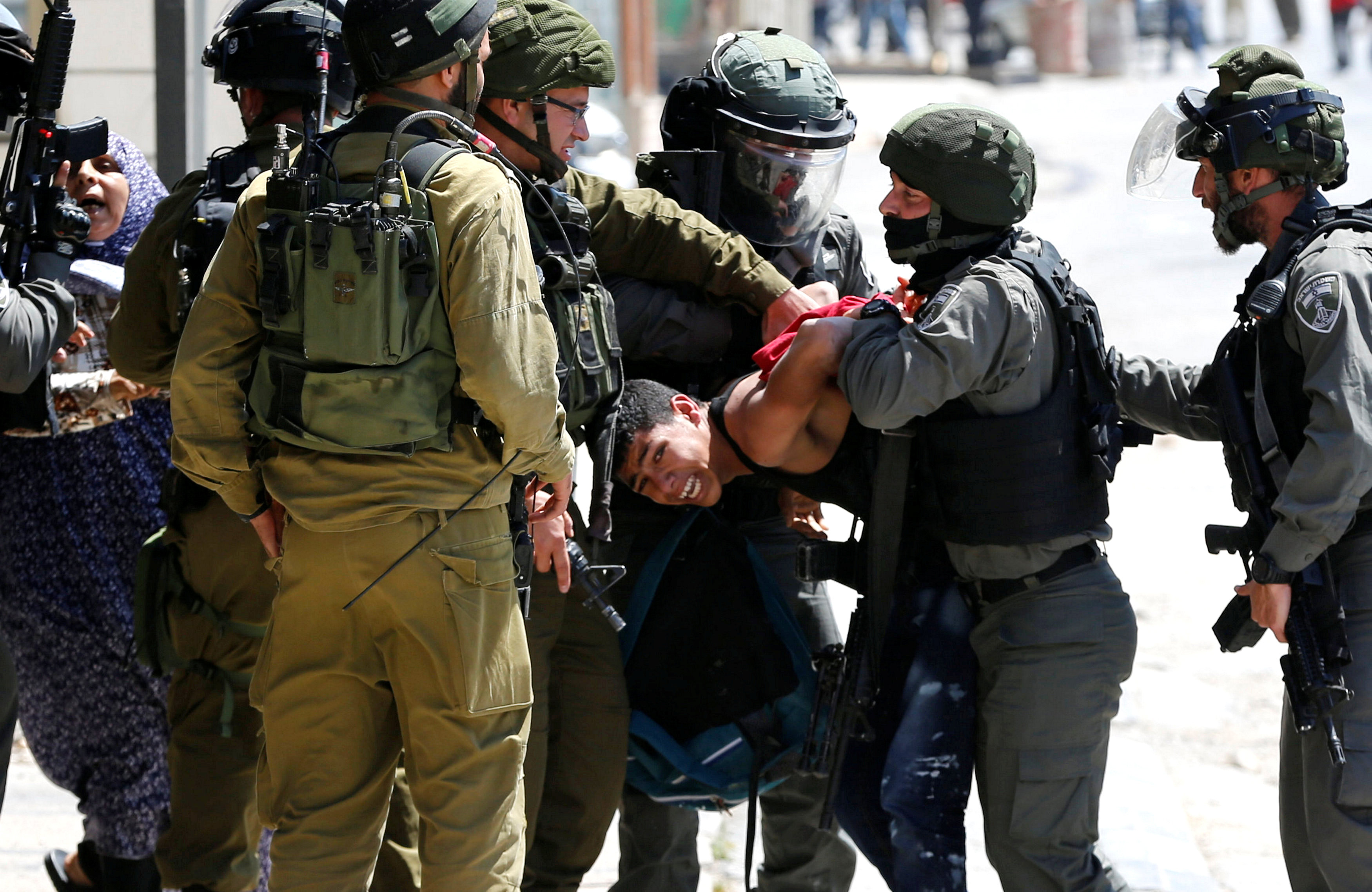 أفراد قوات الاحتلال يتجمعون حول شاب فلسطينى فور اعتقاله