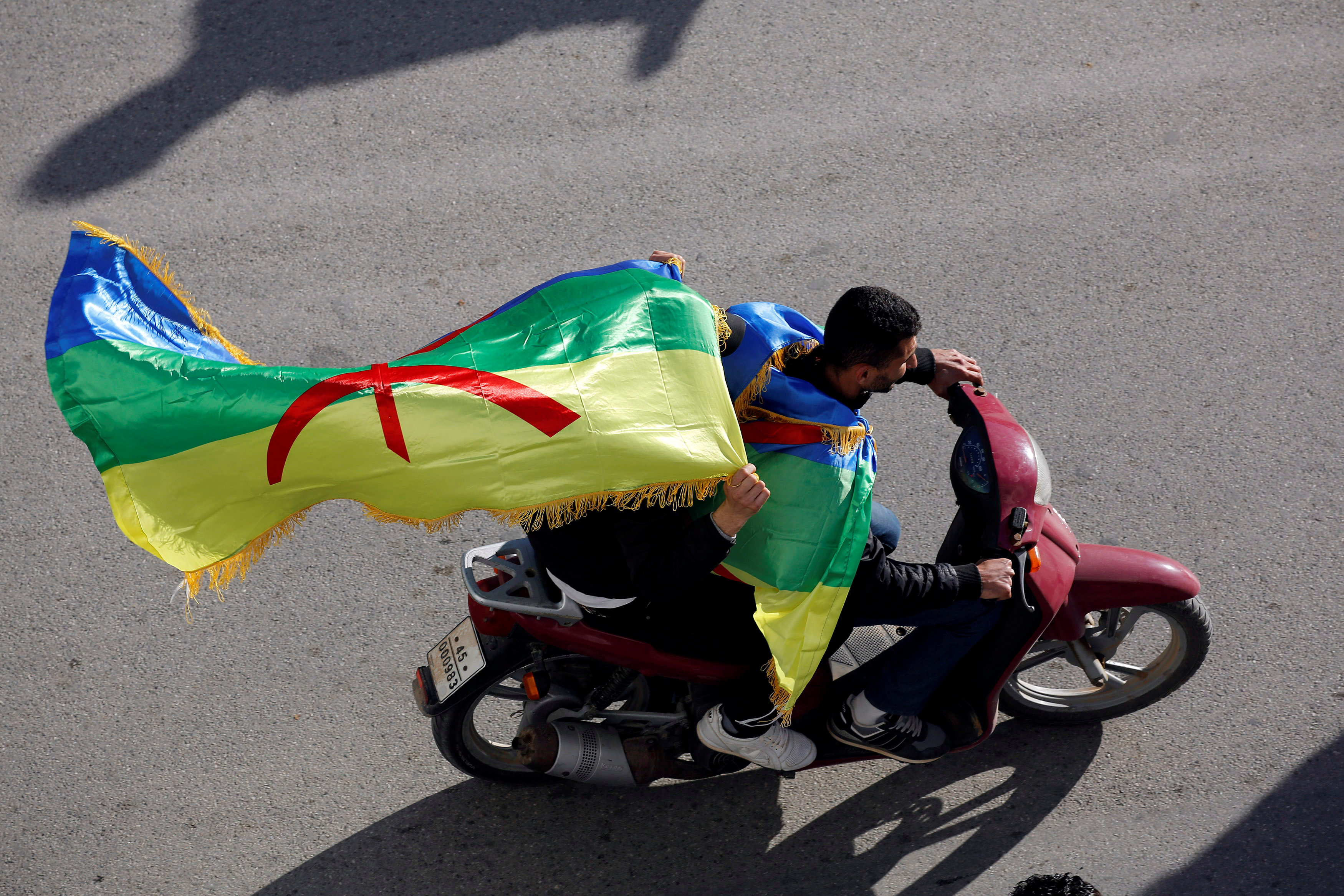 شاب يركب دراجة نارية خلال المظاهرة حاملا علم الأمازيغ