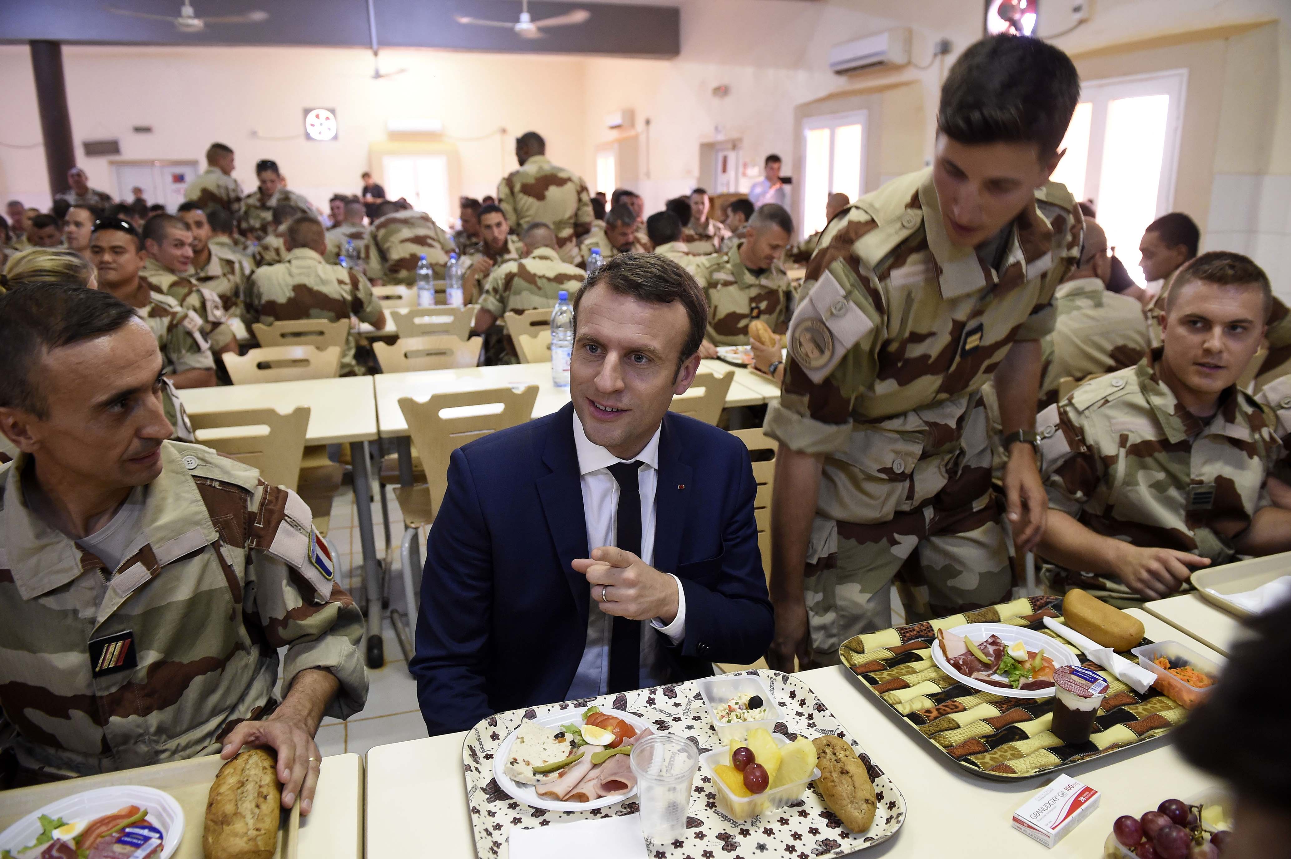 ماكرون يتحدث أثناء  تناول الطعام مع القوات الفرنسية