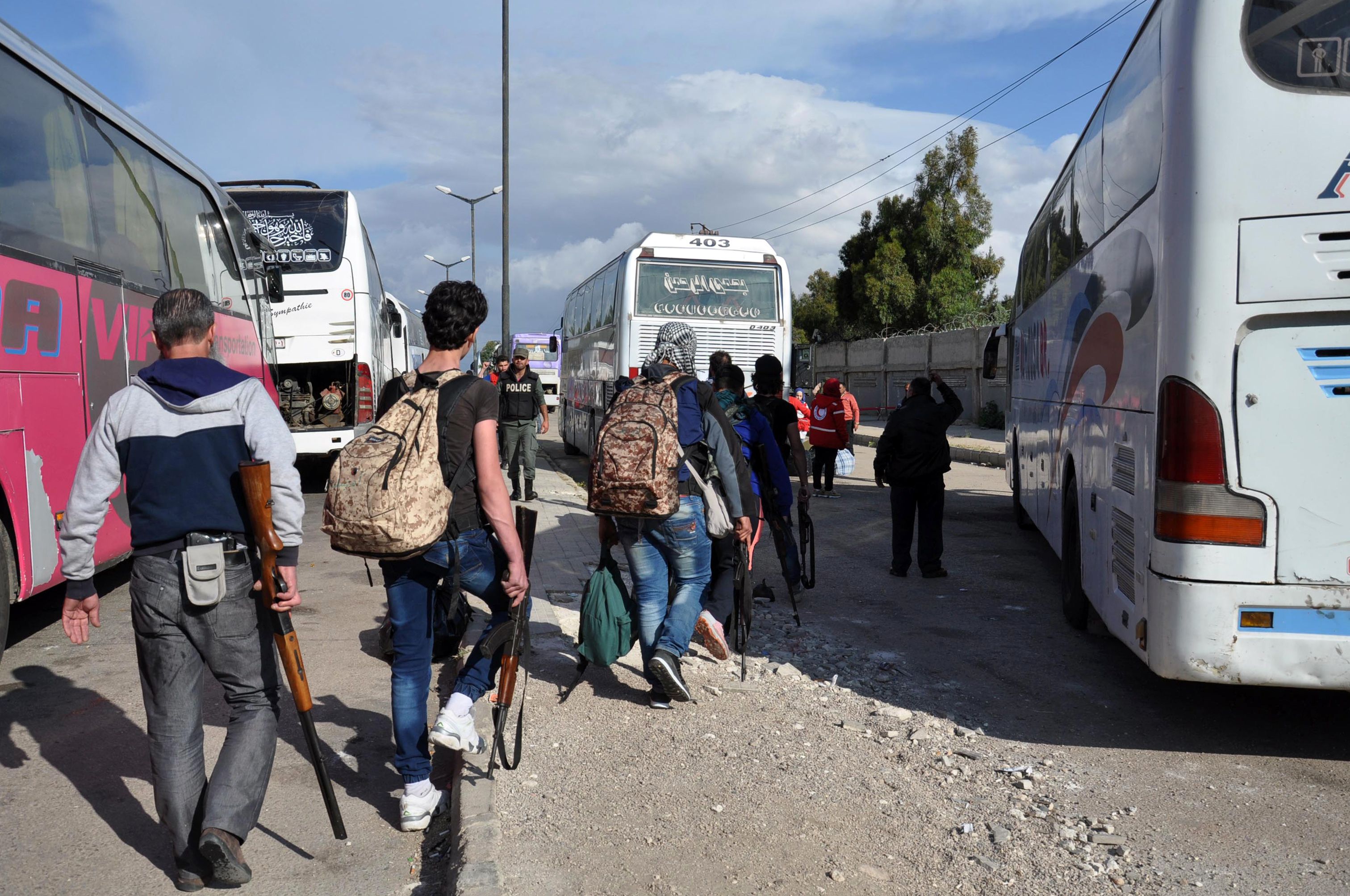 مقاتلو المعارضة السورية يصعدون للحافلات للخروج من حى الوعر