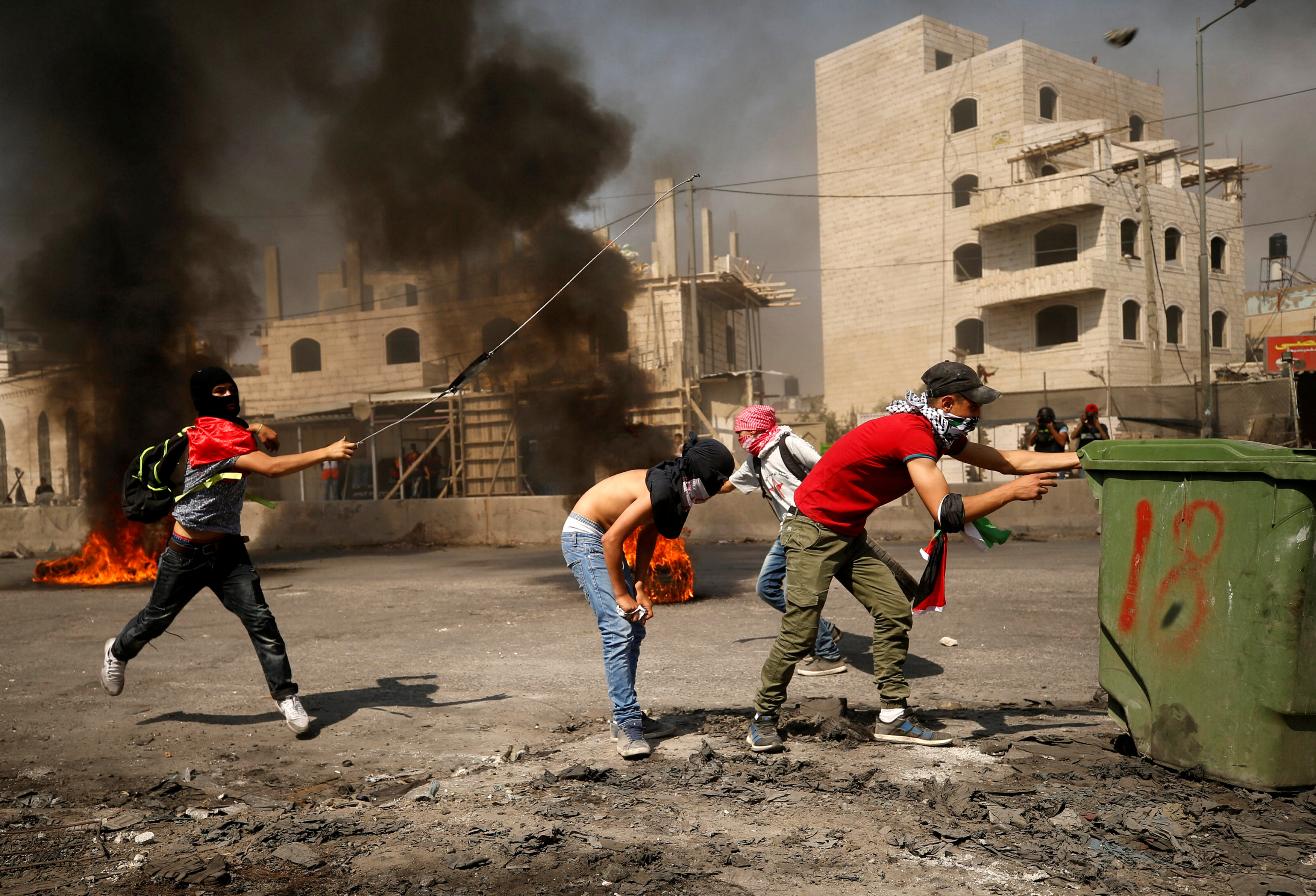 شباب فلسطينيون يحتمون وراء حاجز