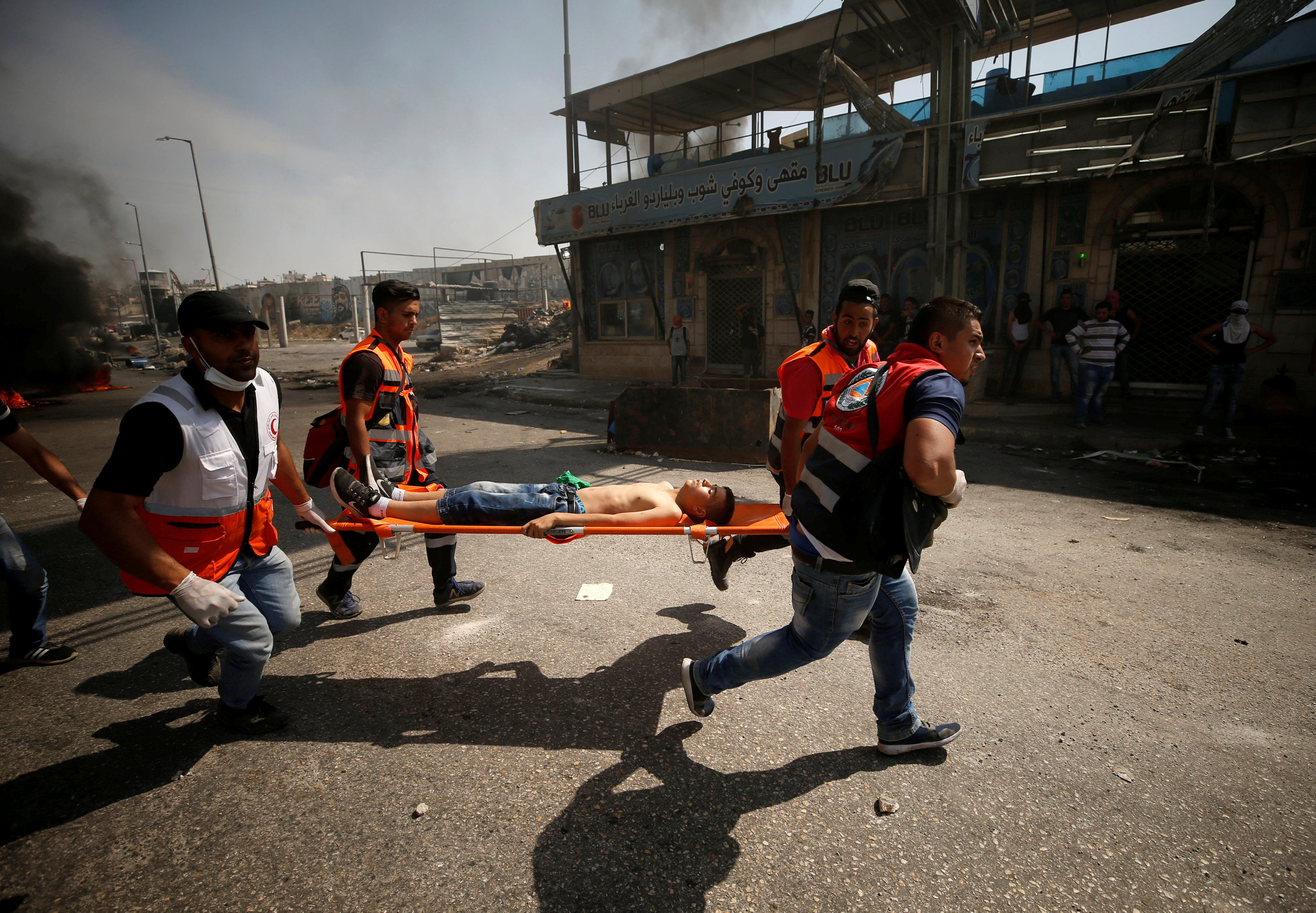 مسعفون يحملون مصابا بعد اشتباكات مع قوات الاحتلال