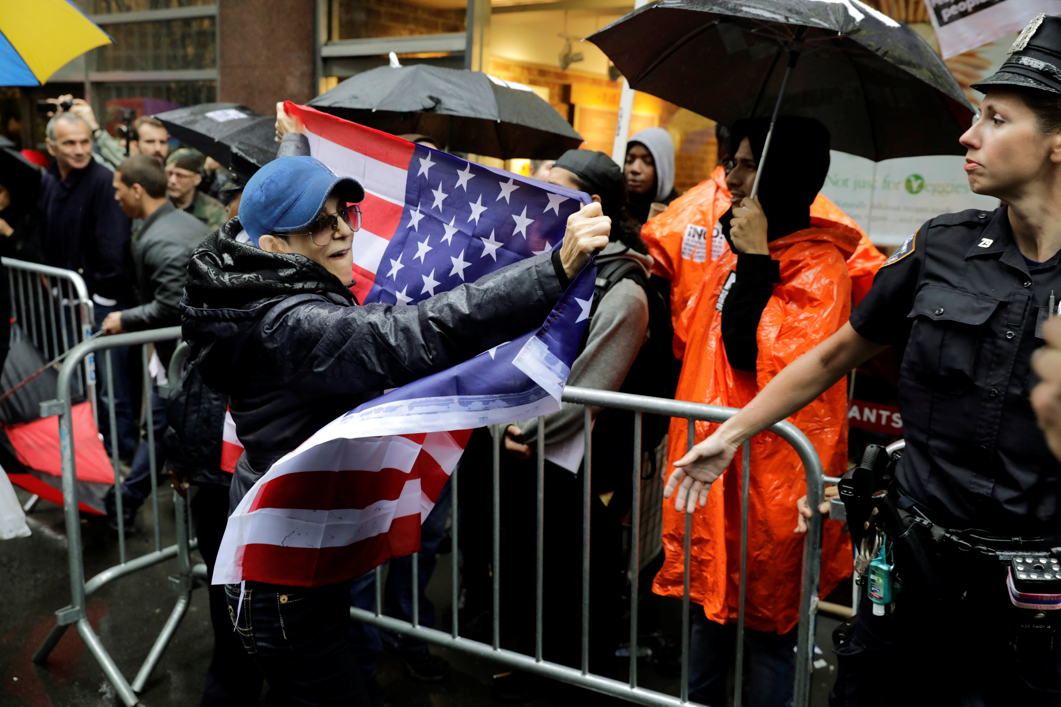 متظاهر ضد الناشطة الفلسطينية يحمل علم أمريكا