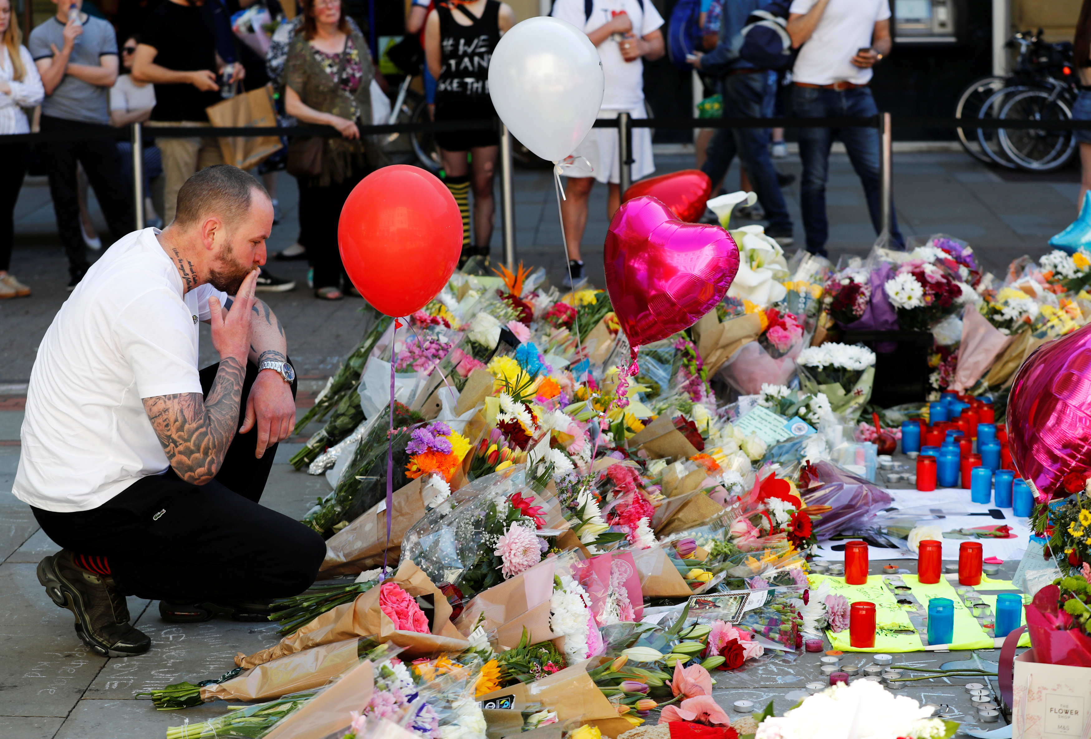 رجل يقبل باقة الورد لتأبين ضحايا هجوم مانشستر