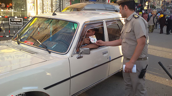   ضابط يعطي امساكية رمضان لاحد السائقين