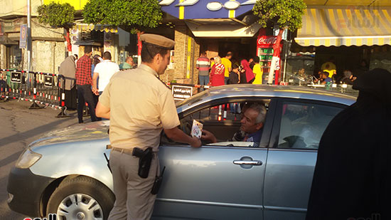    ضابط يوزع امساكية رمضان على السائثين