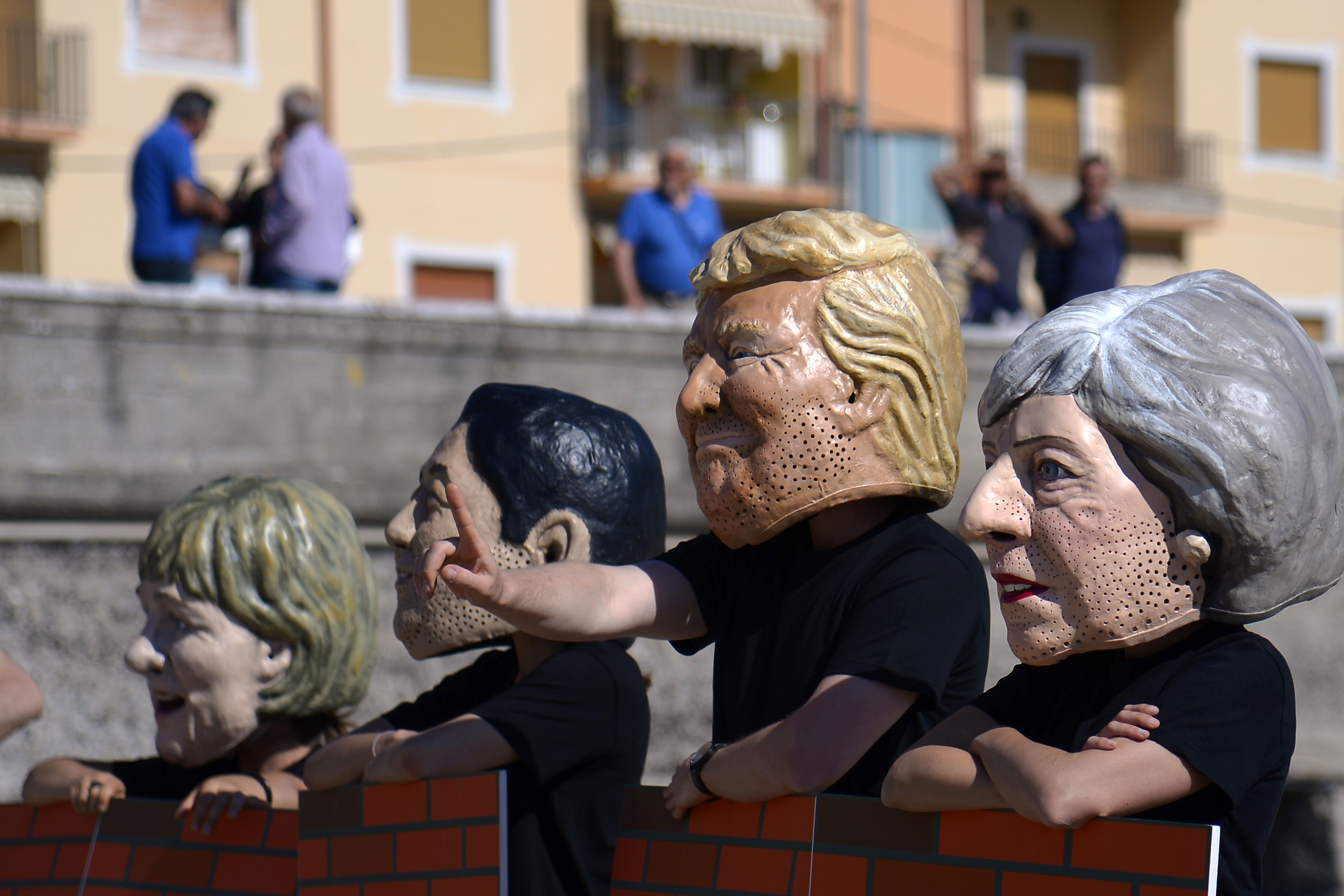 نشطاء يرتدون أقنعة قادة مجموعة السبع فى مظاهرة بايطاليا